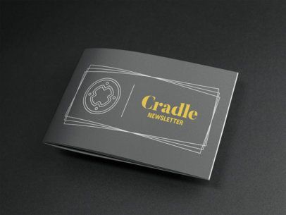 A black brochure with a yellow logo on it is sitting on a black surface.