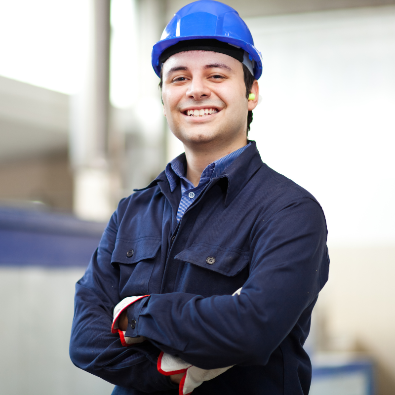 A smiling man wearing a blue hard hat and gloves