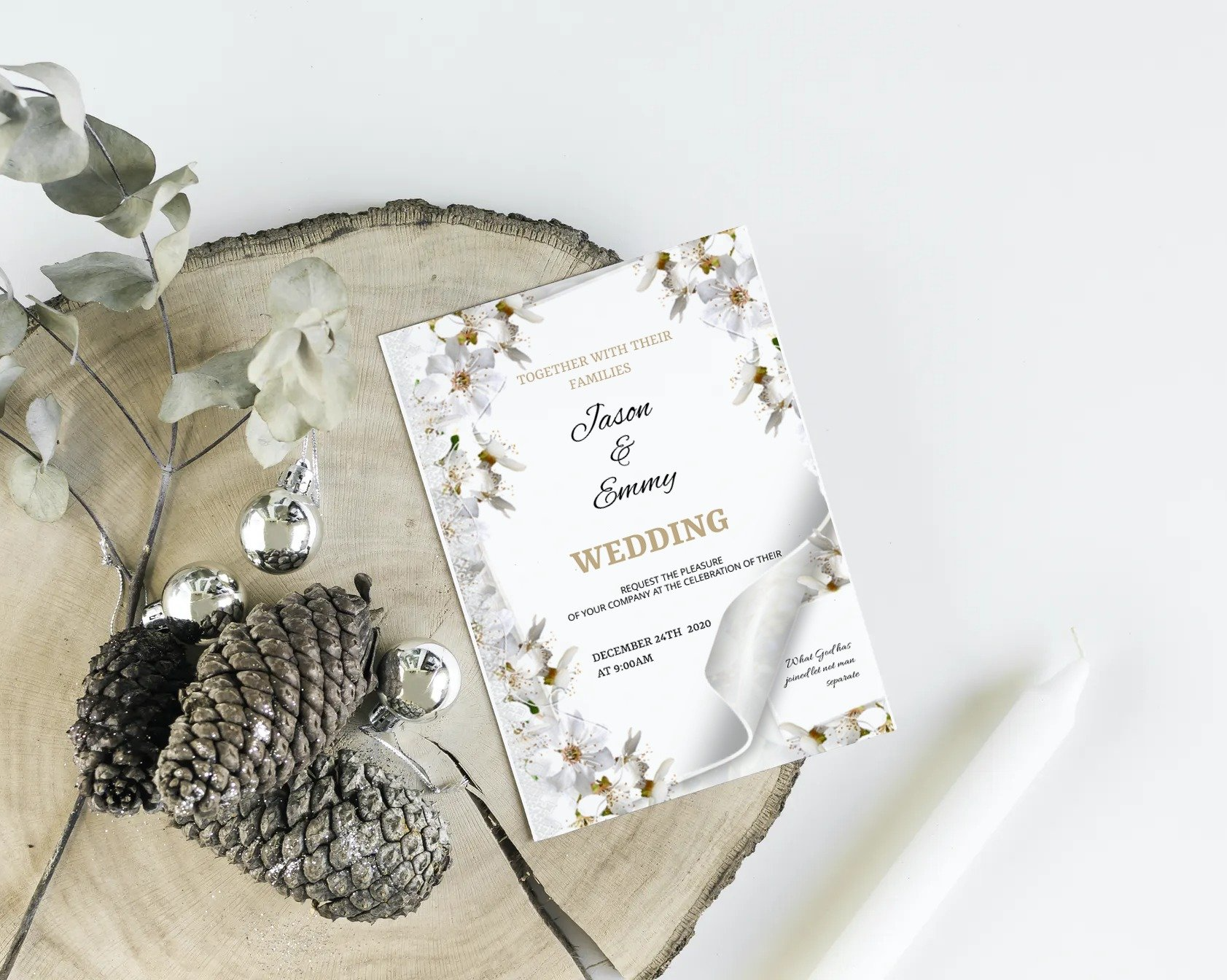 A wedding invitation is sitting on a piece of wood next to a pine cone.