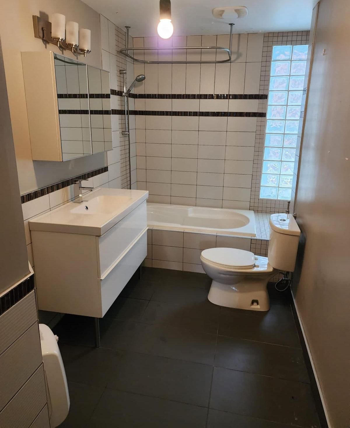 Une salle de bain avec WC, lavabo et baignoire