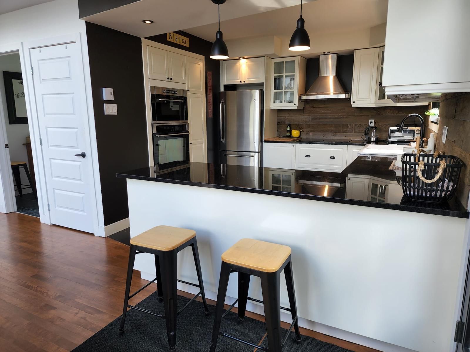 Une cuisine avec des tabourets et un réfrigérateur