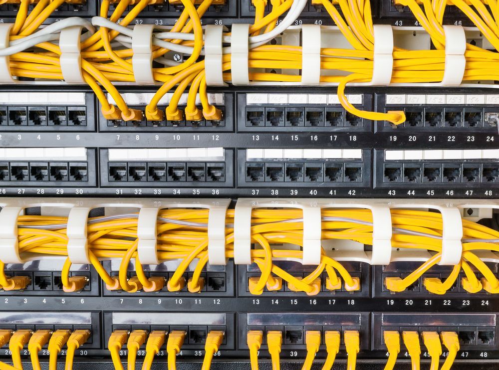 Yellow Network Cables Plugged Into Black Patch Panels — A & J Electrical Contractors in Barraba, NSW