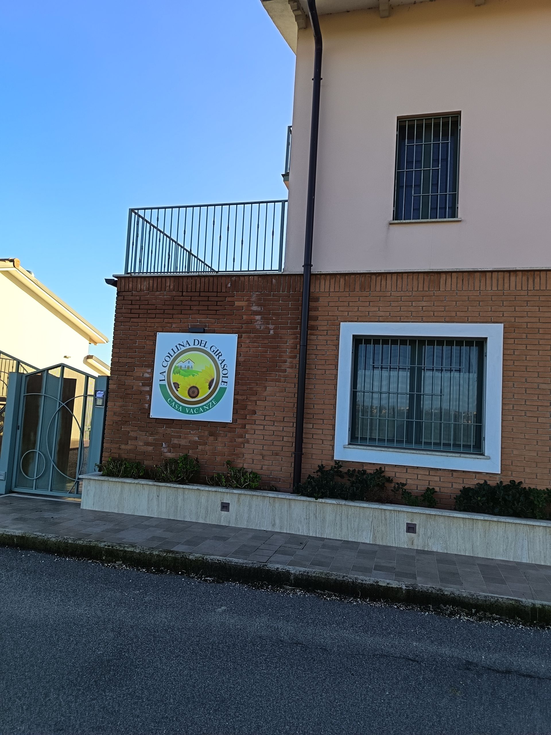 Un edificio a due piani di colore chiaro con facciata in mattoni