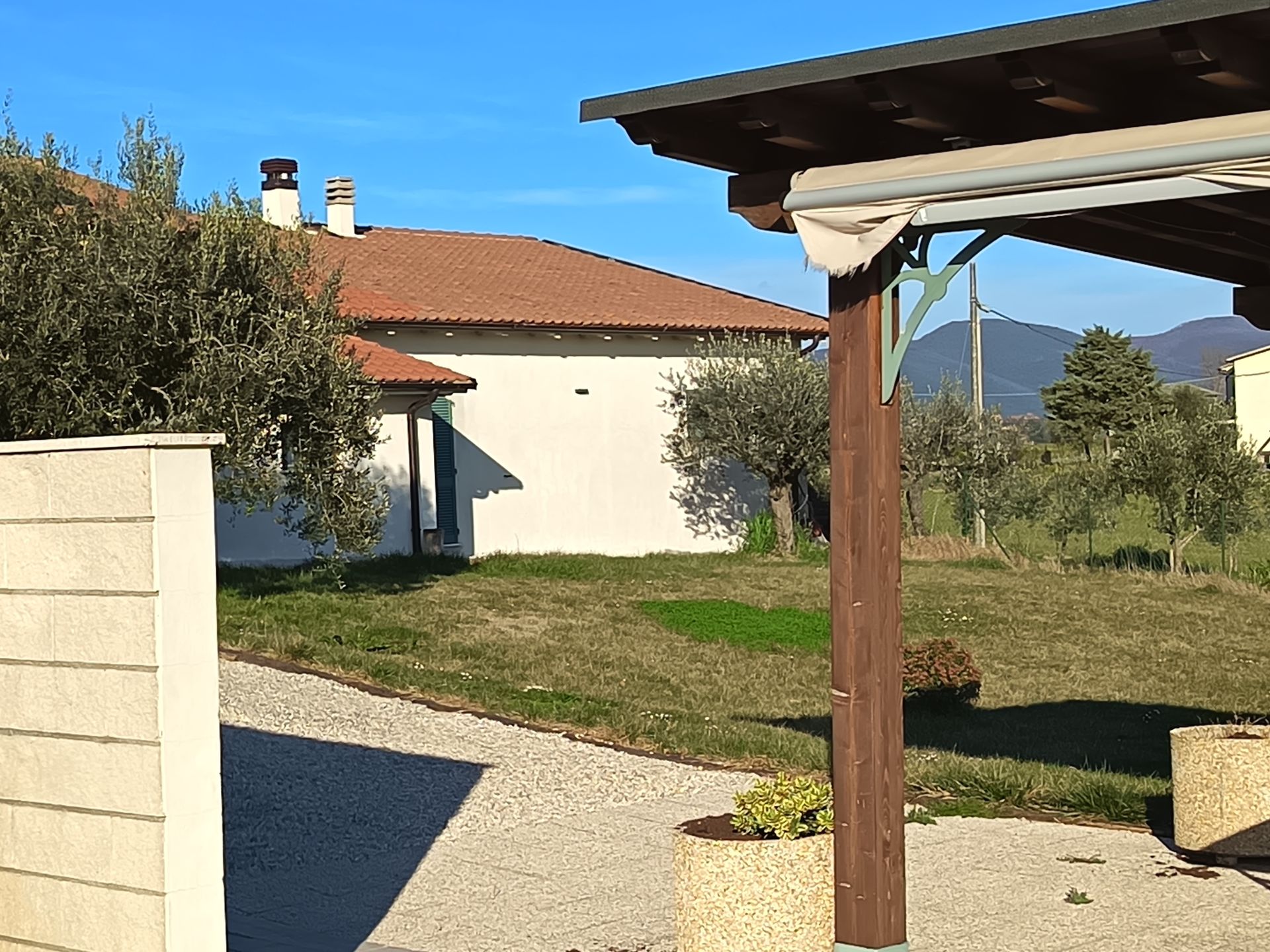 Una soleggiata scena all'aperto con una casa bianca dal tetto di tegole