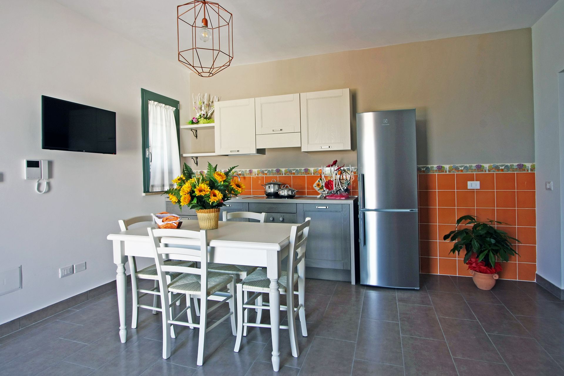 Una cucina e zona pranzo con mobili bianchi