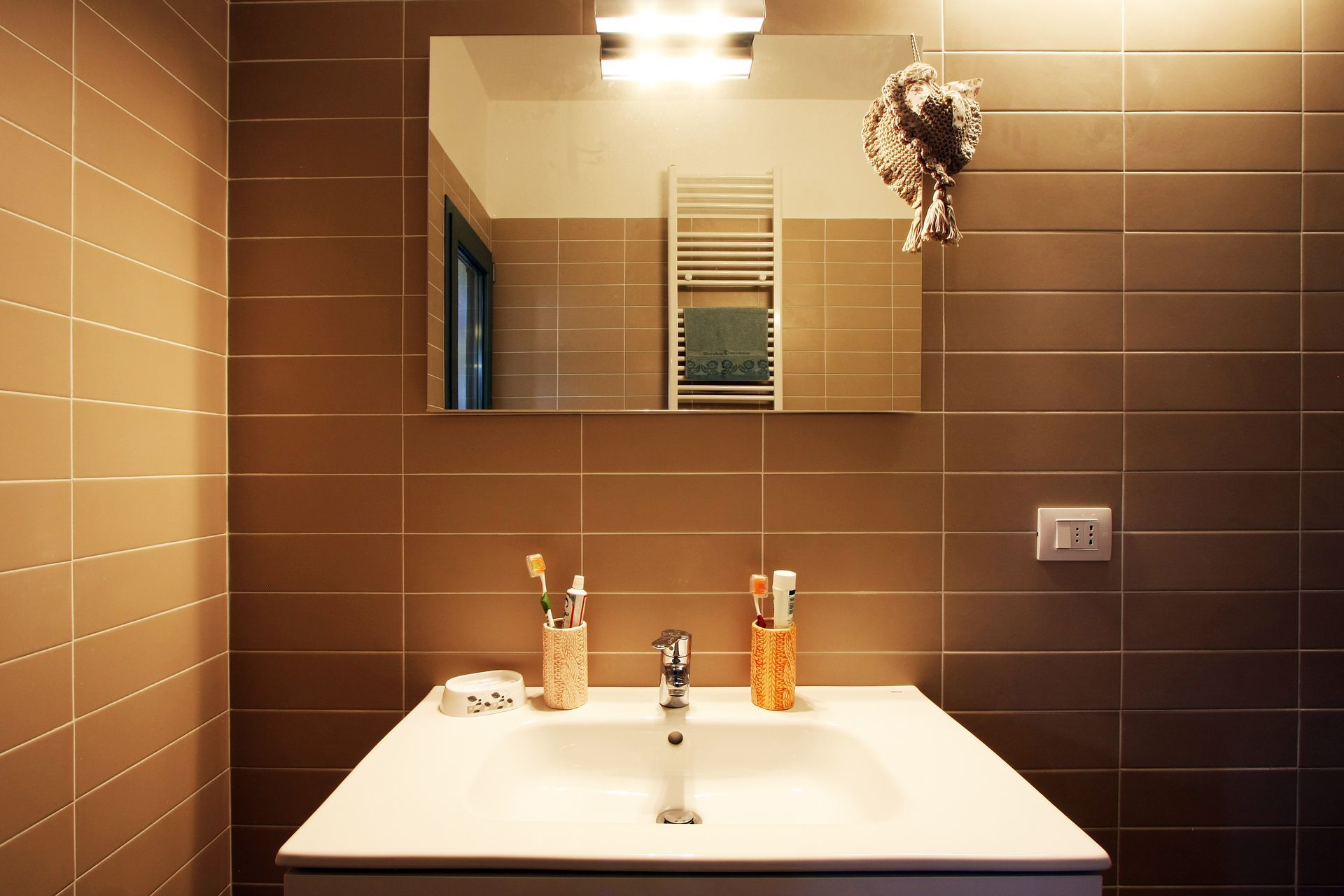 Un moderno lavabo da bagno con vasca bianca, portaspazzolini