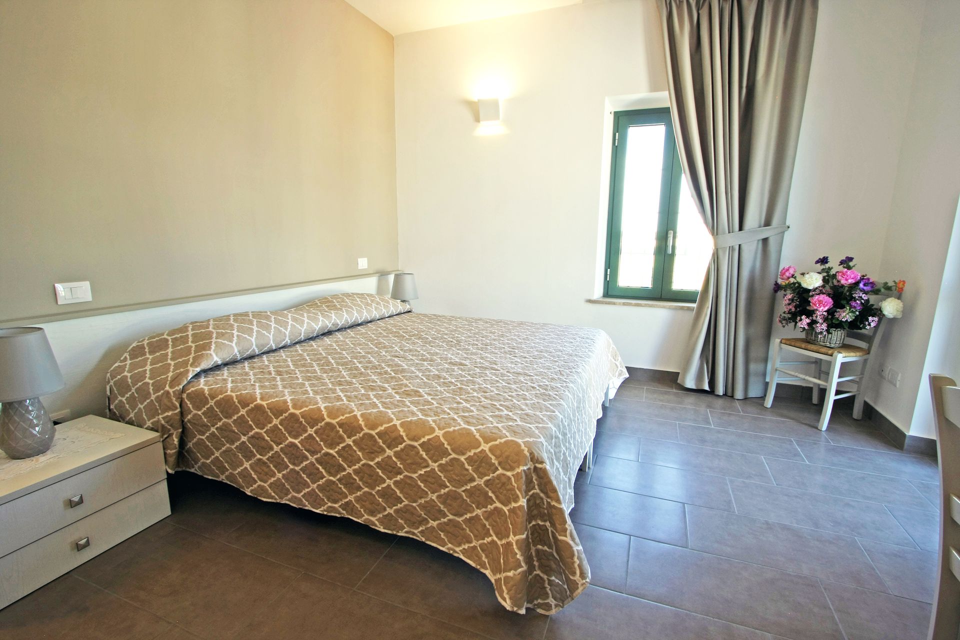 Una camera da letto con un letto con una trapunta a fantasia beige