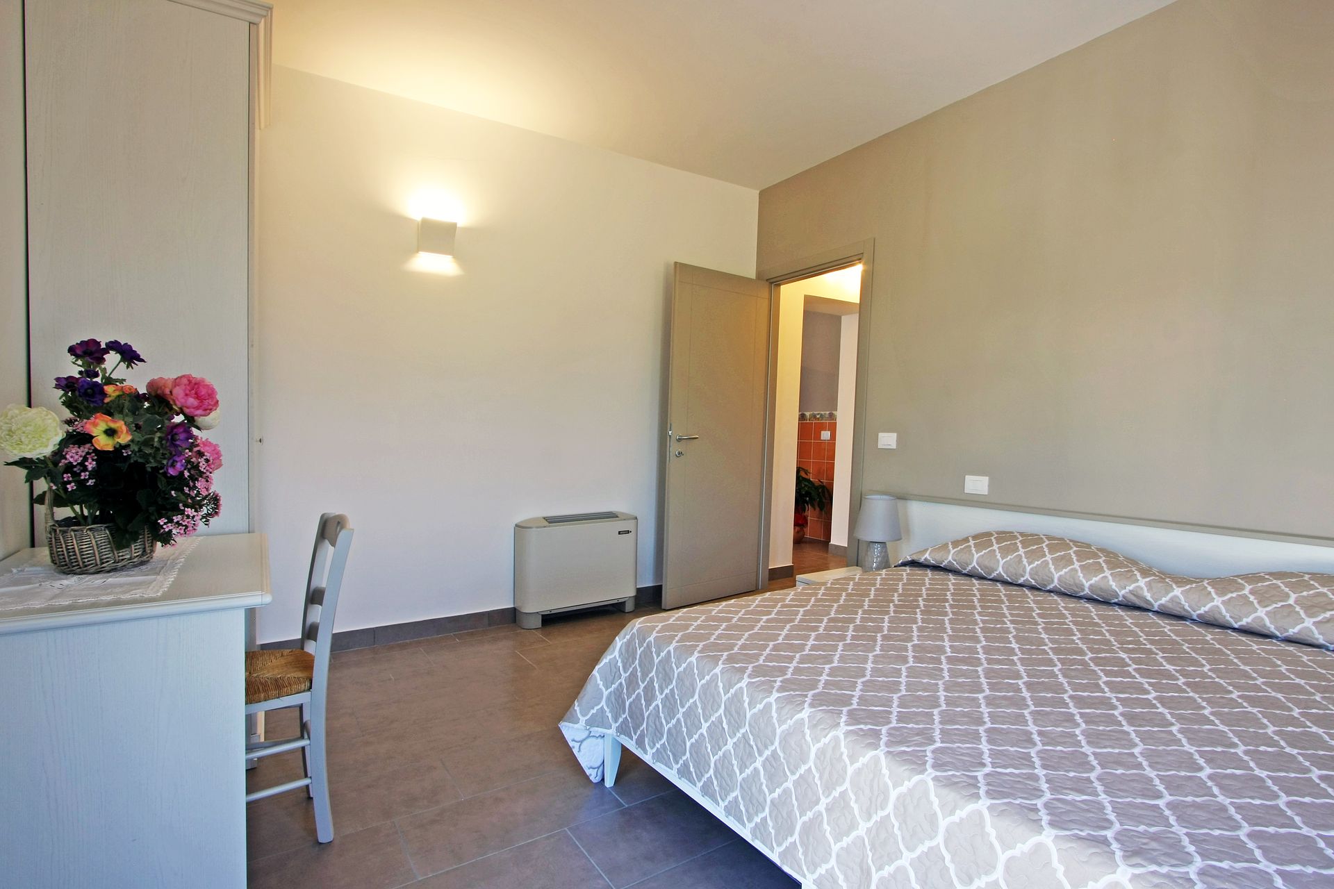 Una camera da letto con un letto con una coperta geometrica grigia e bianca