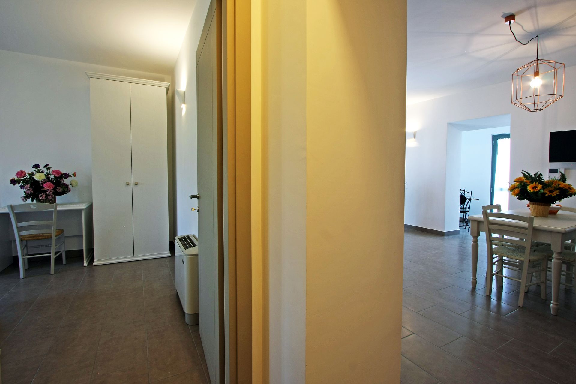 Una vista attraverso una porta sull'interno di un'abitazione con un armadio bianco