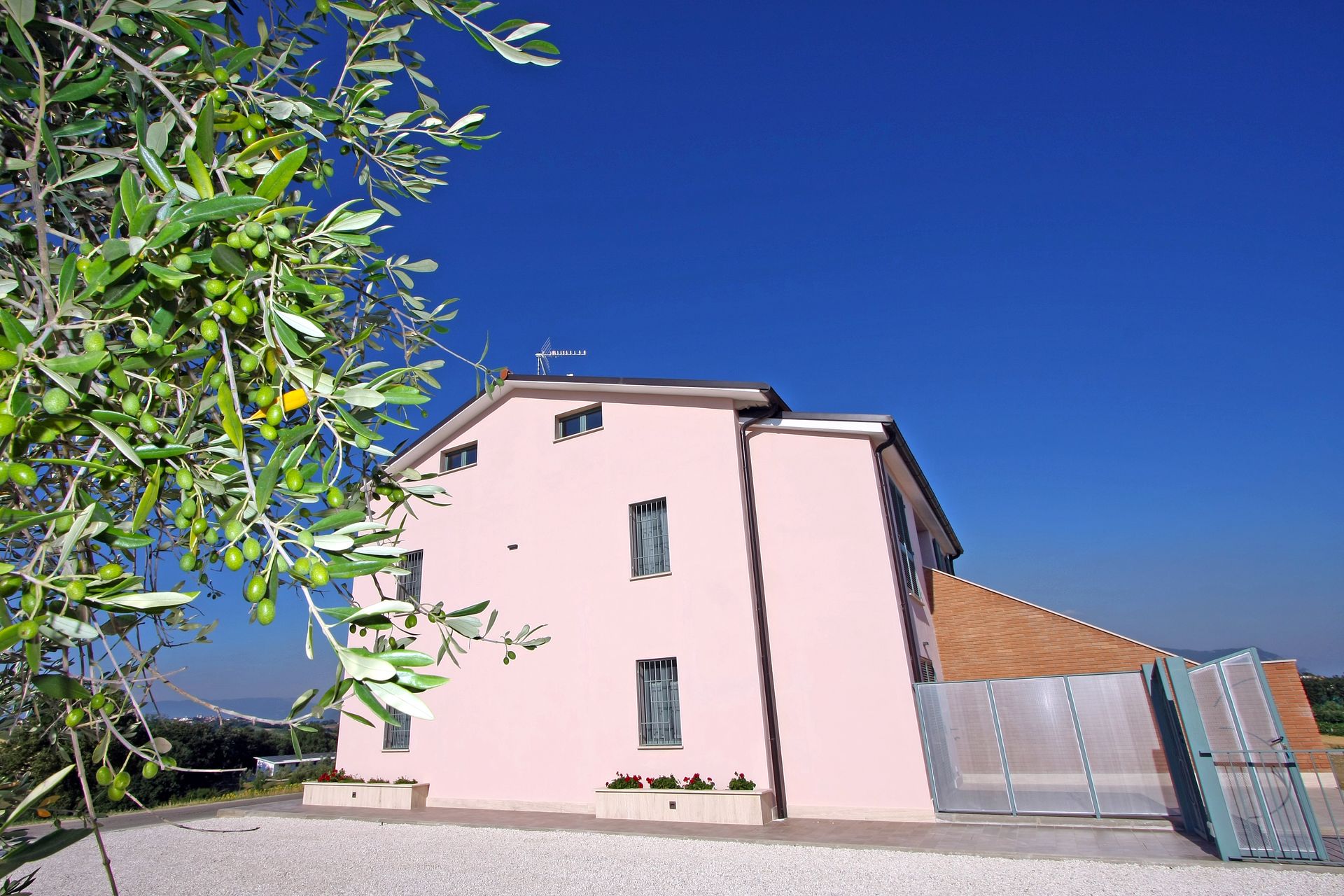 Sotto un cielo azzurro e limpido, si erge una casa rosa a più piani