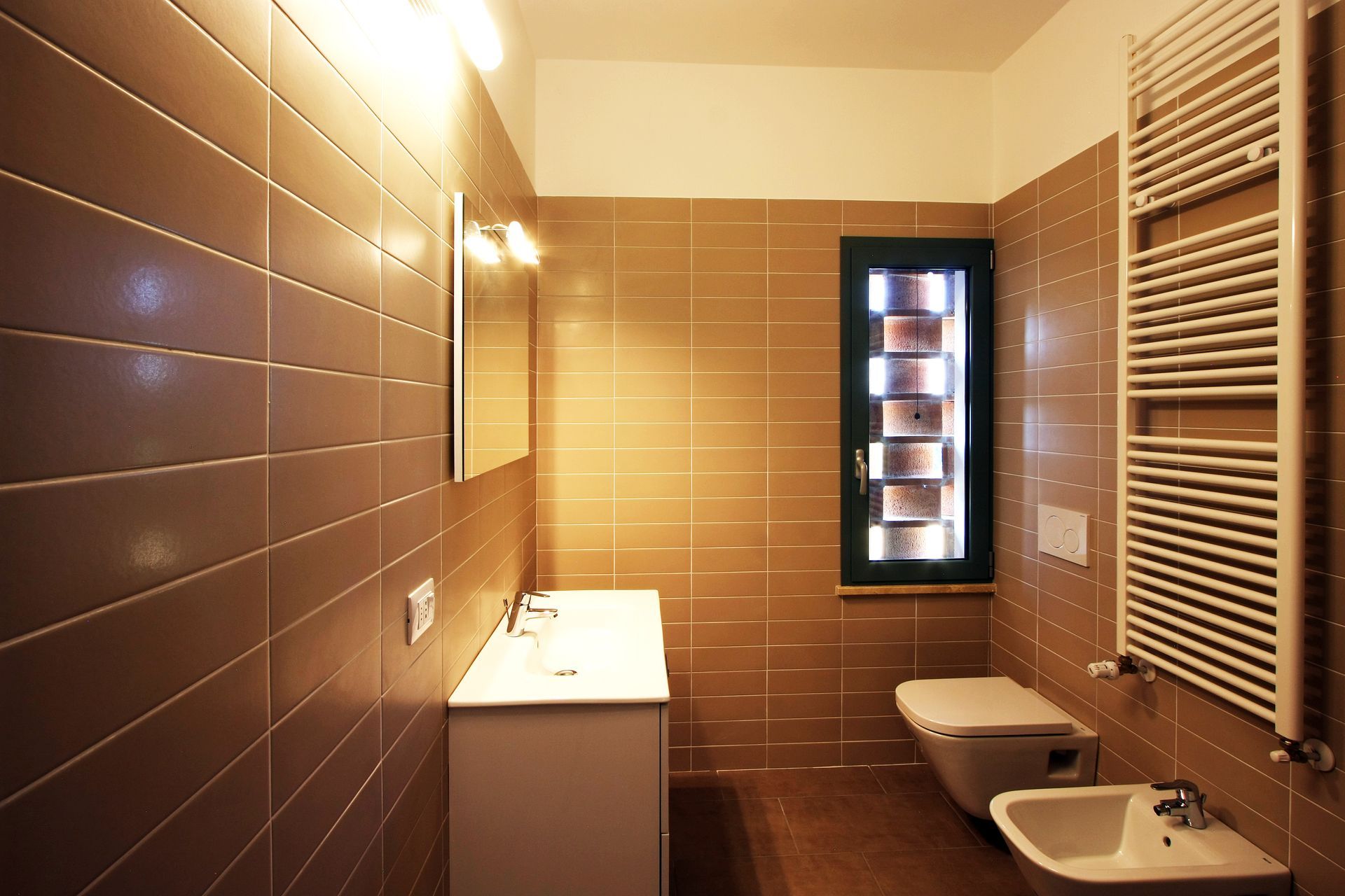Un bagno moderno con pareti rivestite di piastrelle color beige