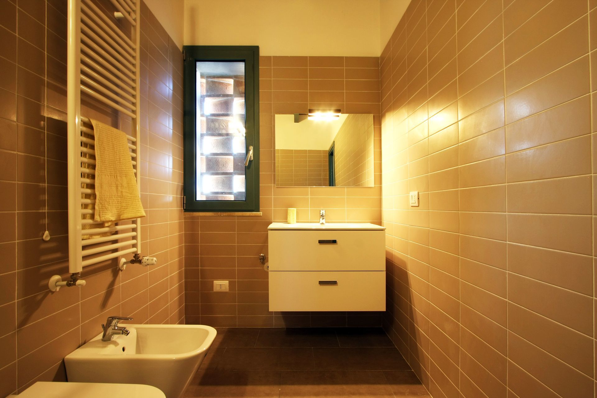 Bagno moderno con pareti rivestite in piastrelle color tortora