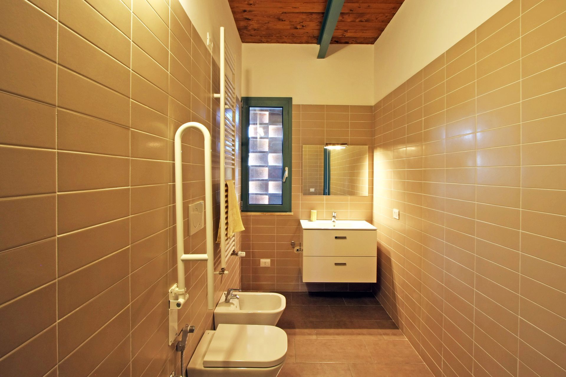 Un bagno moderno con pareti rivestite di piastrelle beige