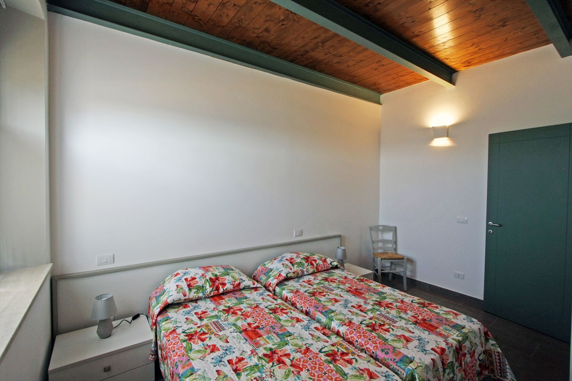 Una camera da letto con due letti singoli con lenzuola a fantasia floreale