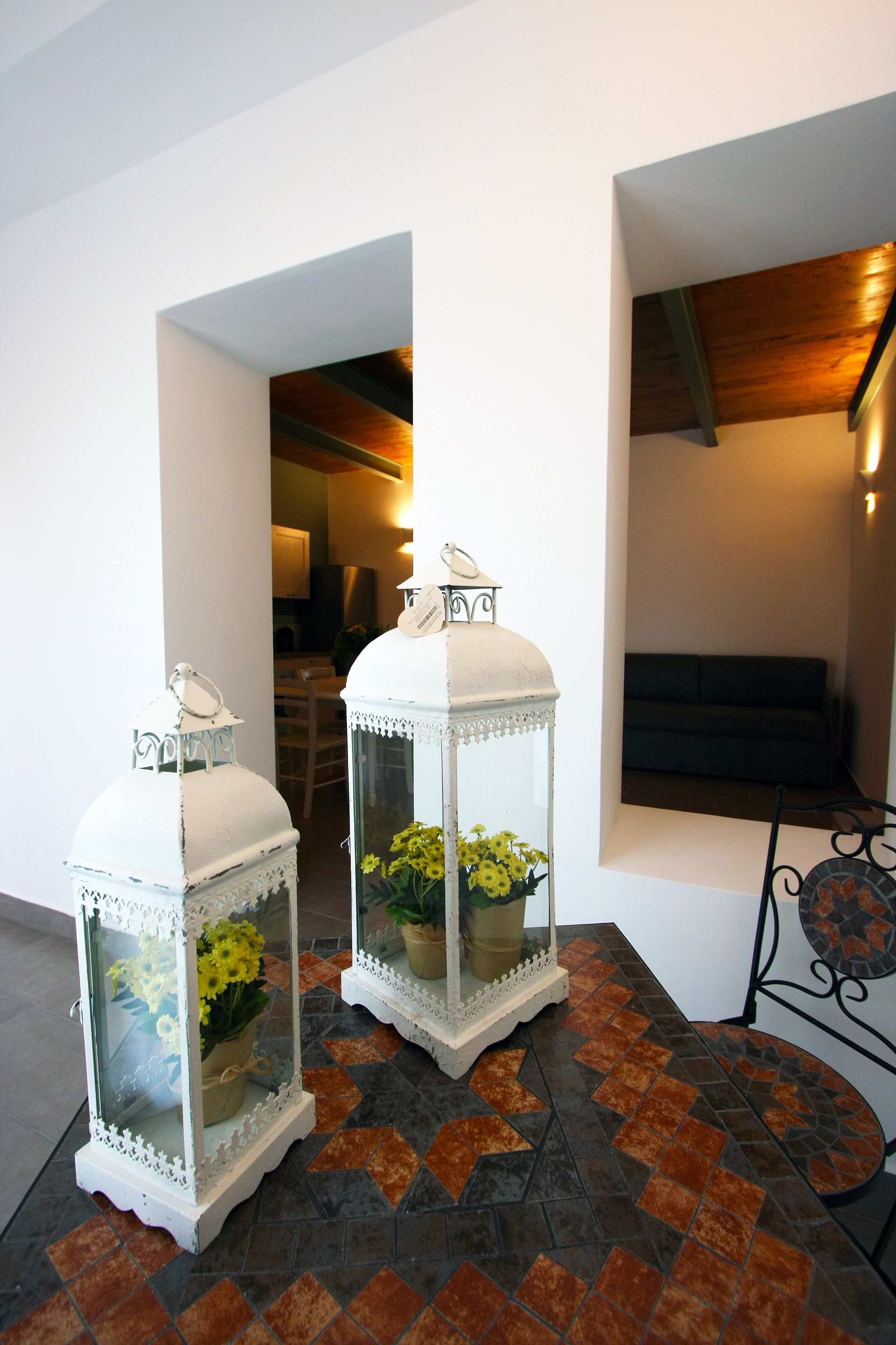 Su un tavolo piastrellato sono appoggiate due lanterne decorative bianche