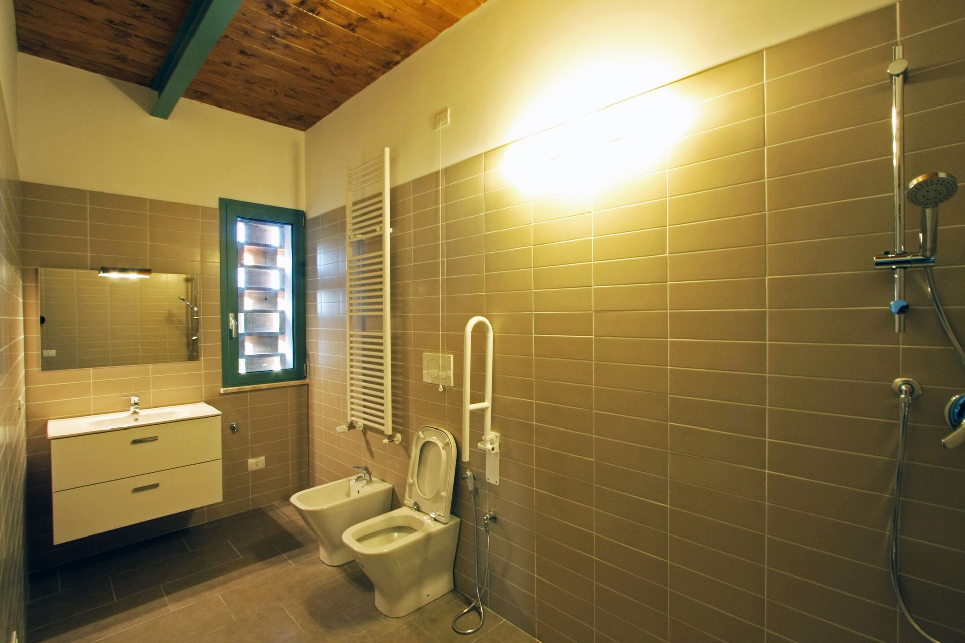 Un bagno moderno e accessibile con pareti rivestite di piastrelle beige