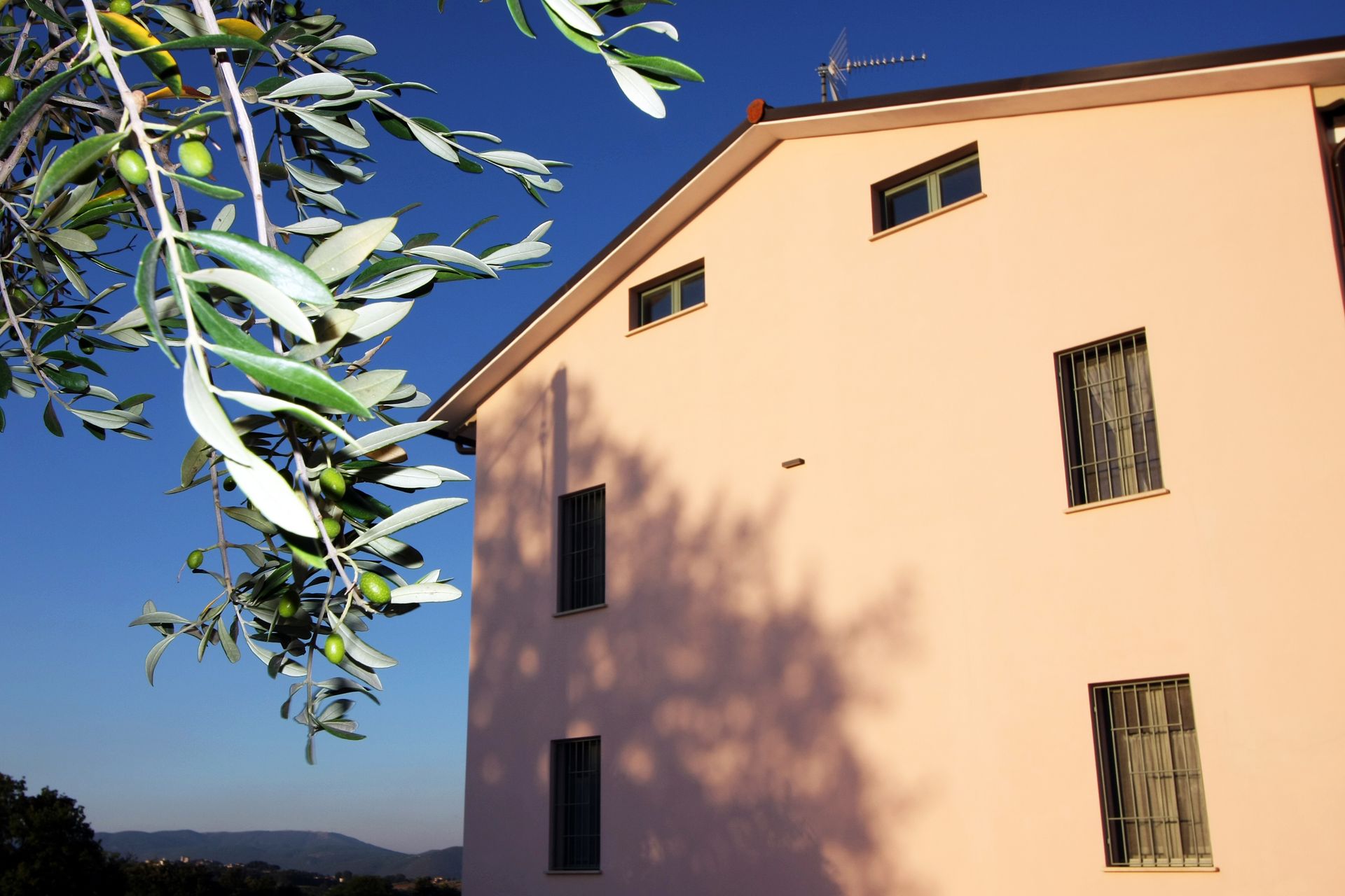 La facciata di un edificio color arancio pallido sotto un cielo azzurro limpido