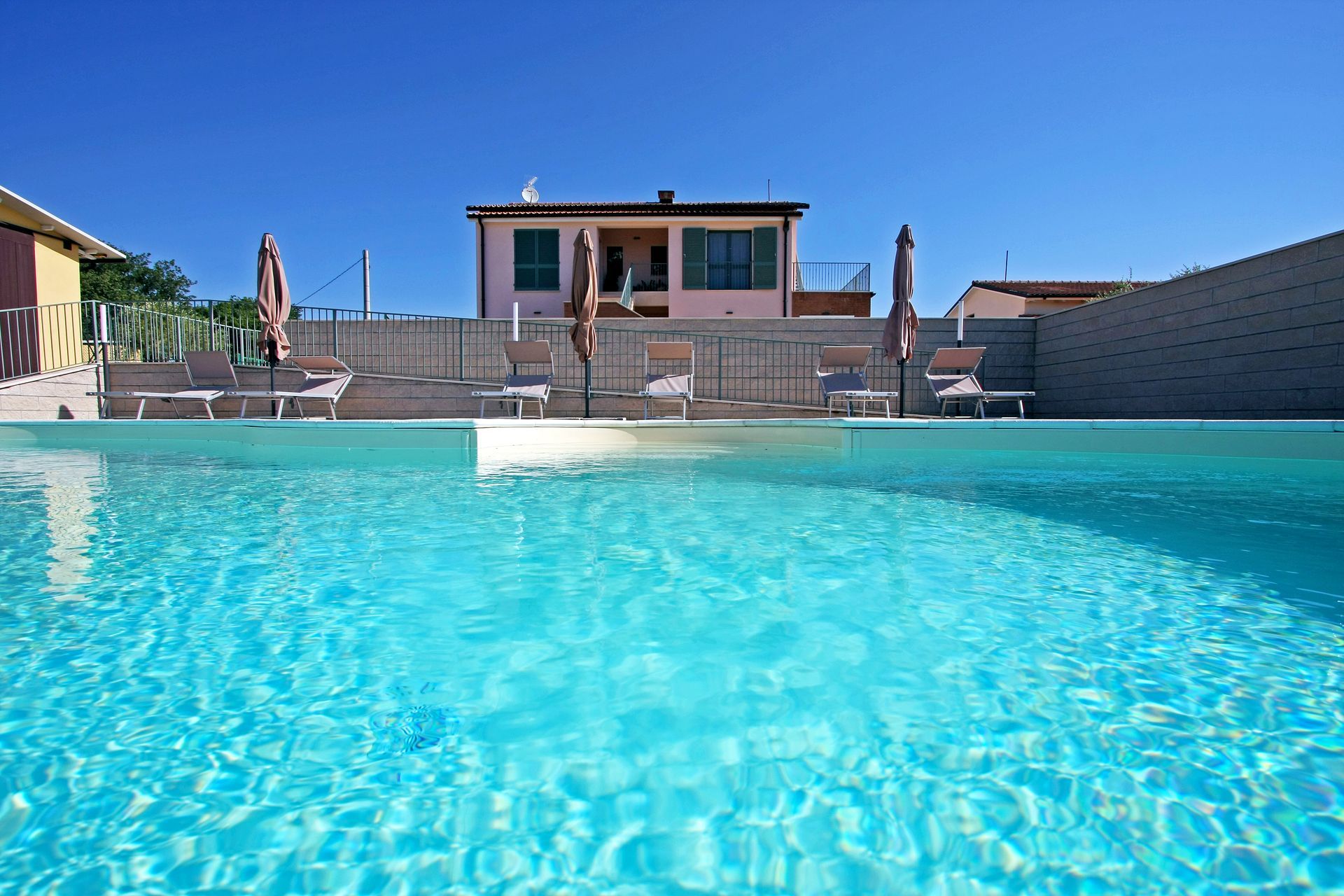 Piscina esterna circondata da paesaggio collinare.