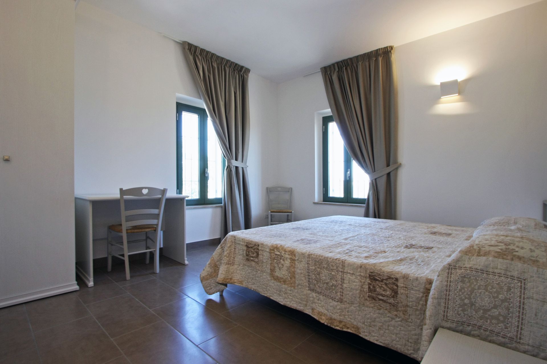 Una camera da letto con un letto con un copriletto beige dalla trama particolare