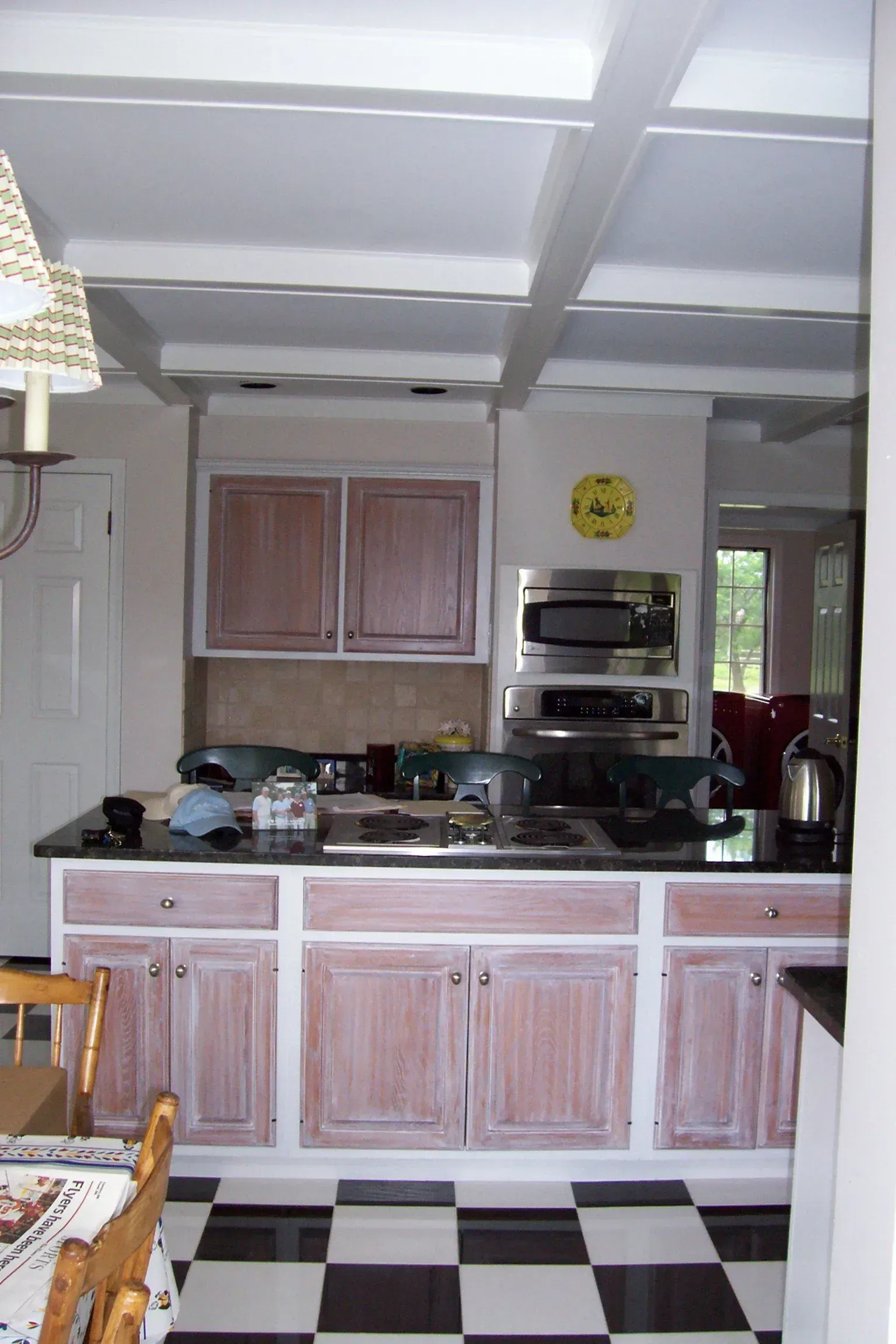 A kitchen with pink cabinets and a checkered floor