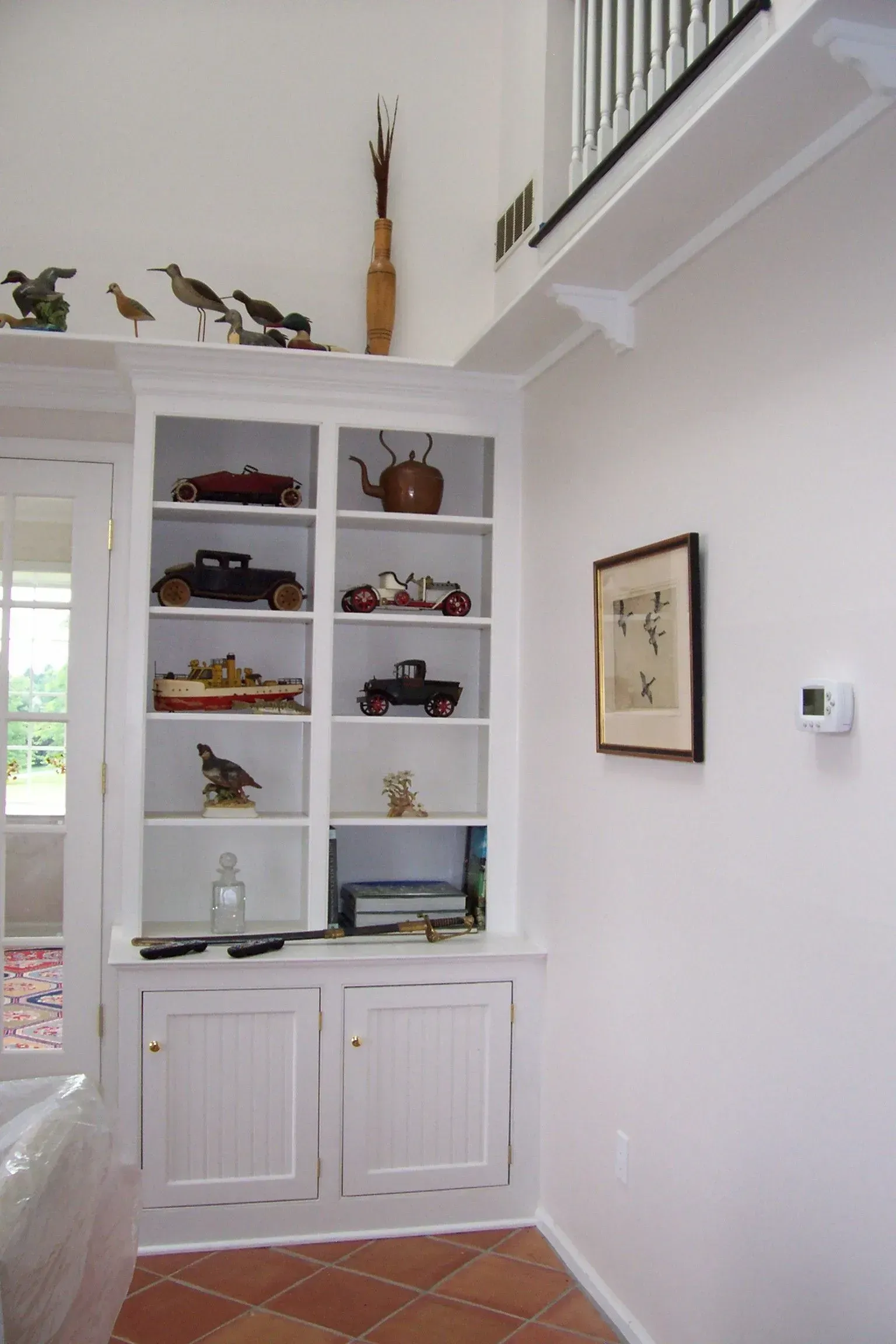 A white shelf with a picture on it