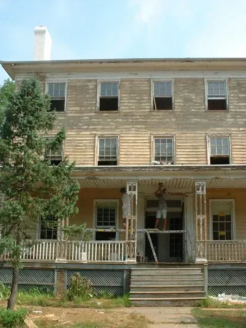 A large wooden house with a porch and many windows
