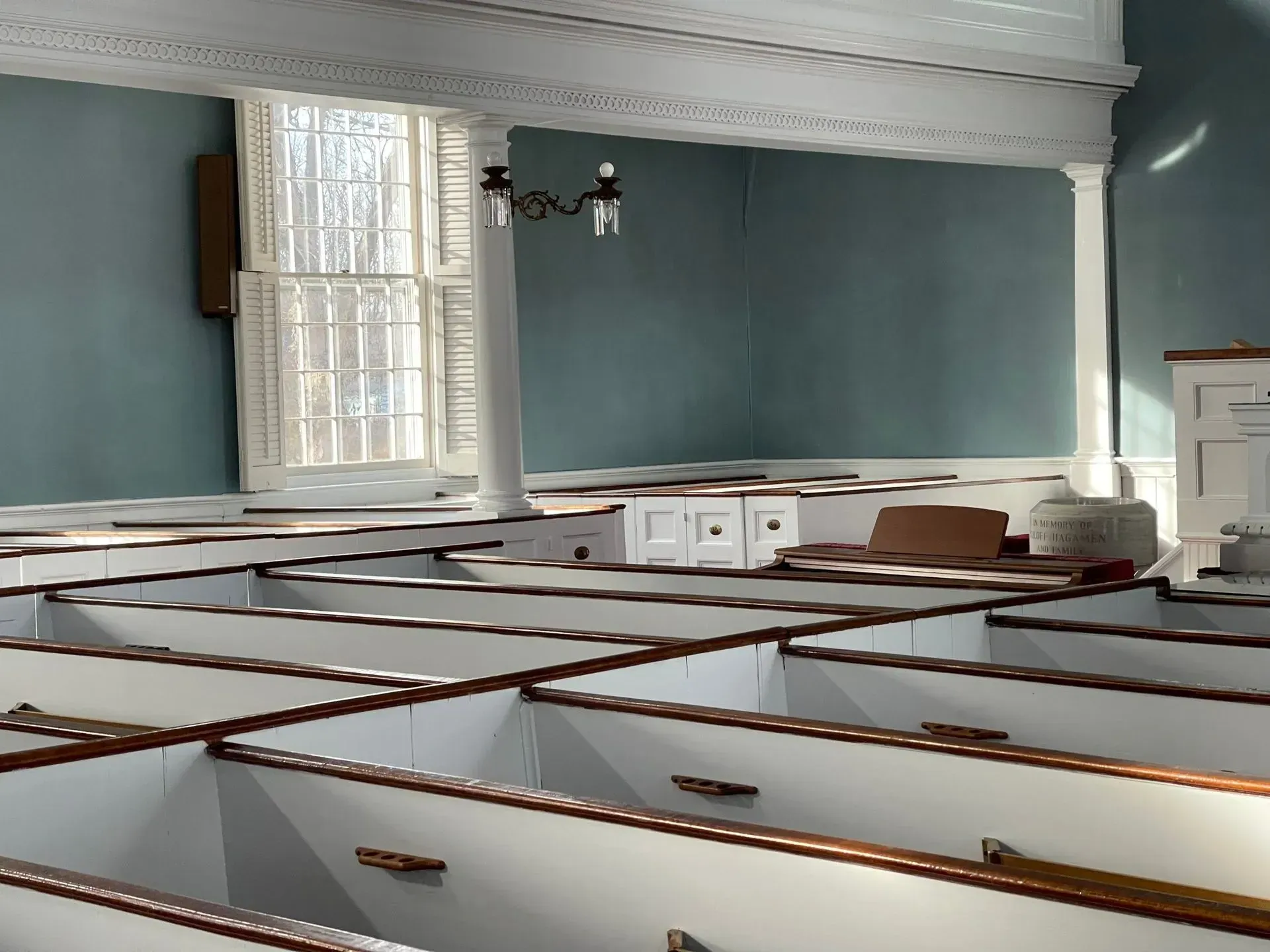 A church with rows of white pews and a window