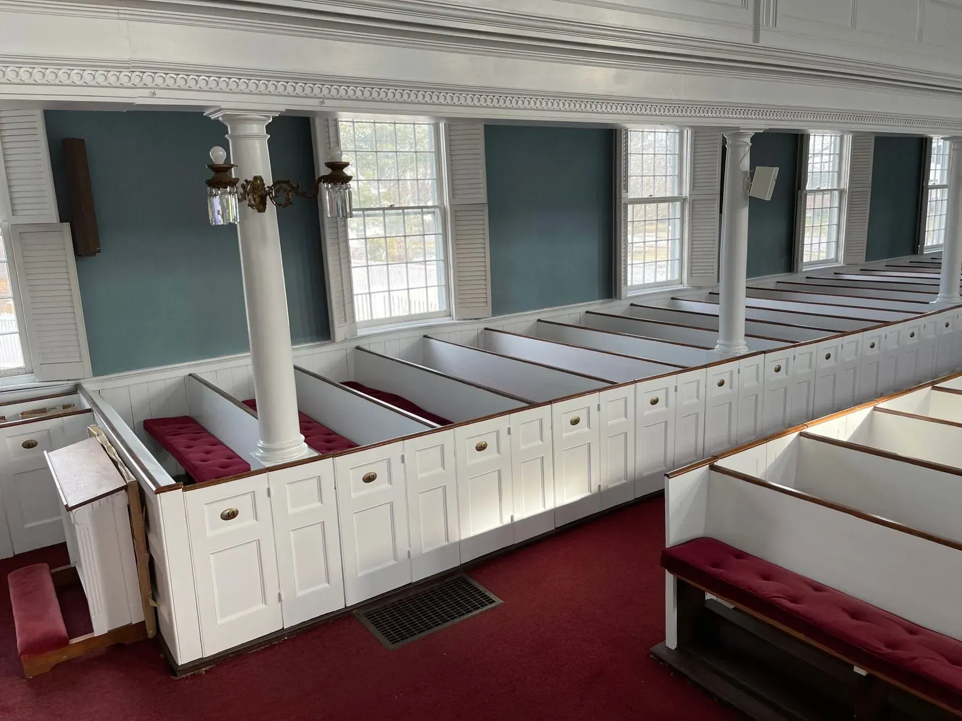 A church with rows of white benches and red cushions