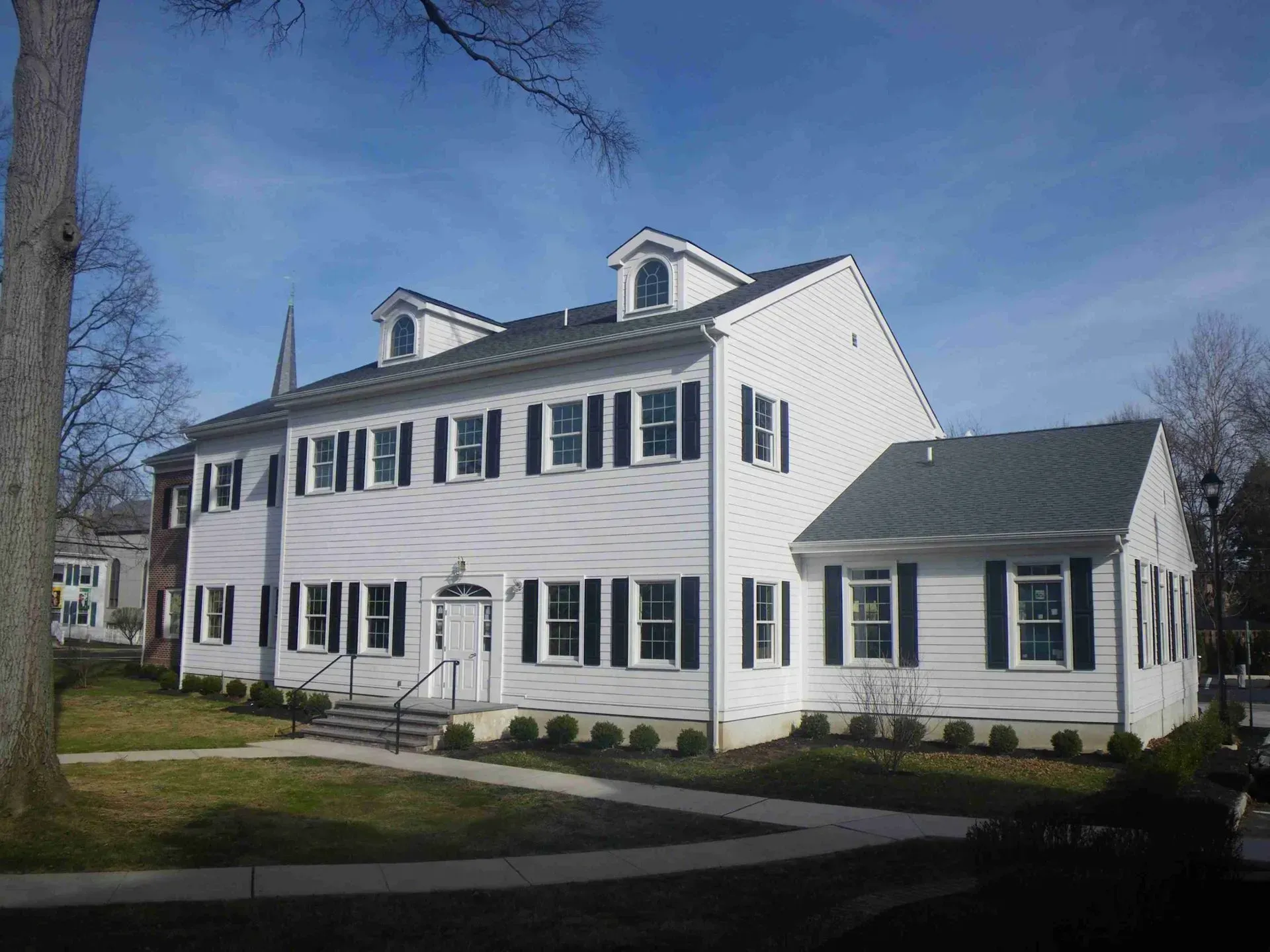 A large white house with black shutters on the windows