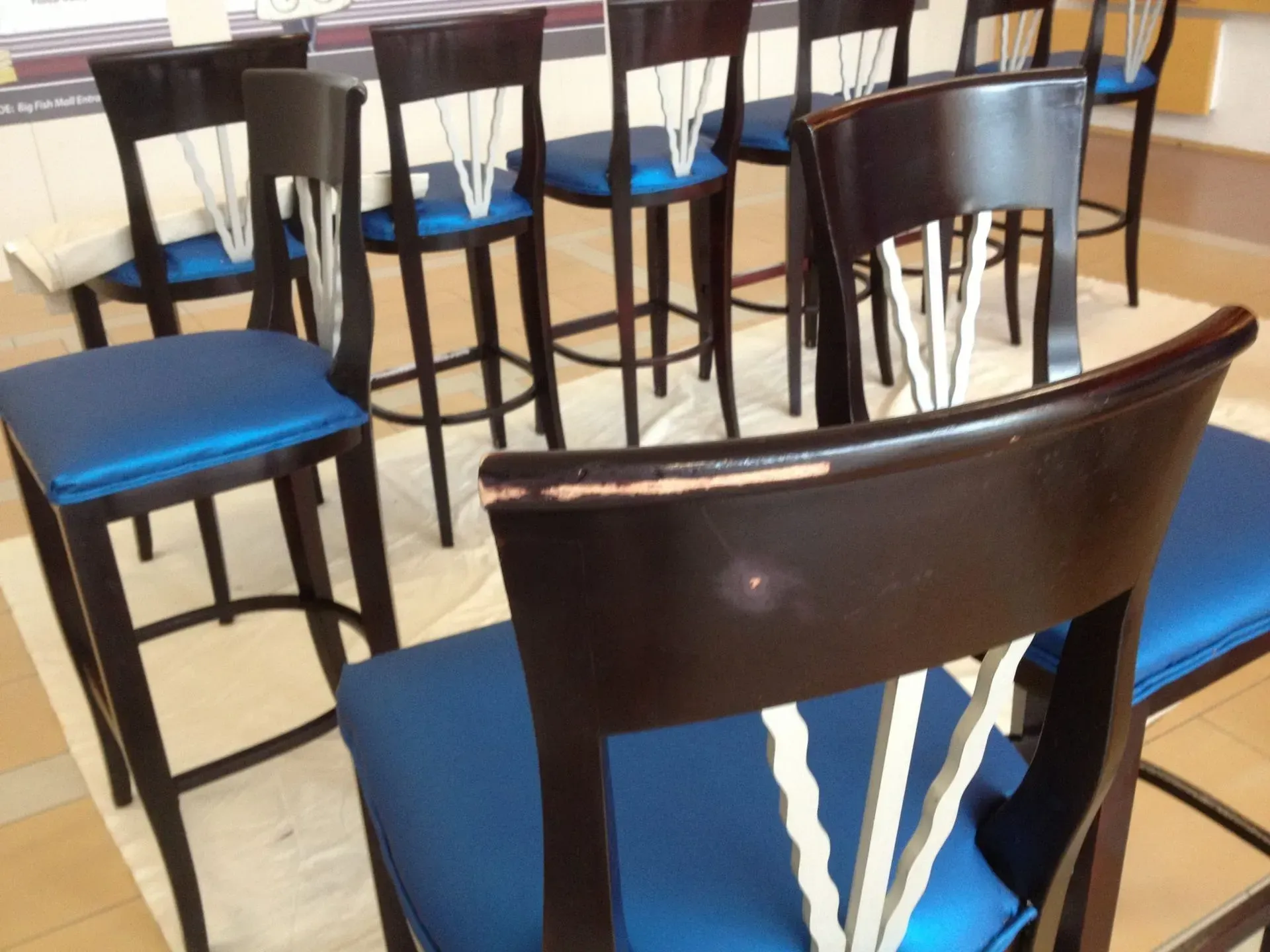A row of chairs with blue cushions are lined up in a room