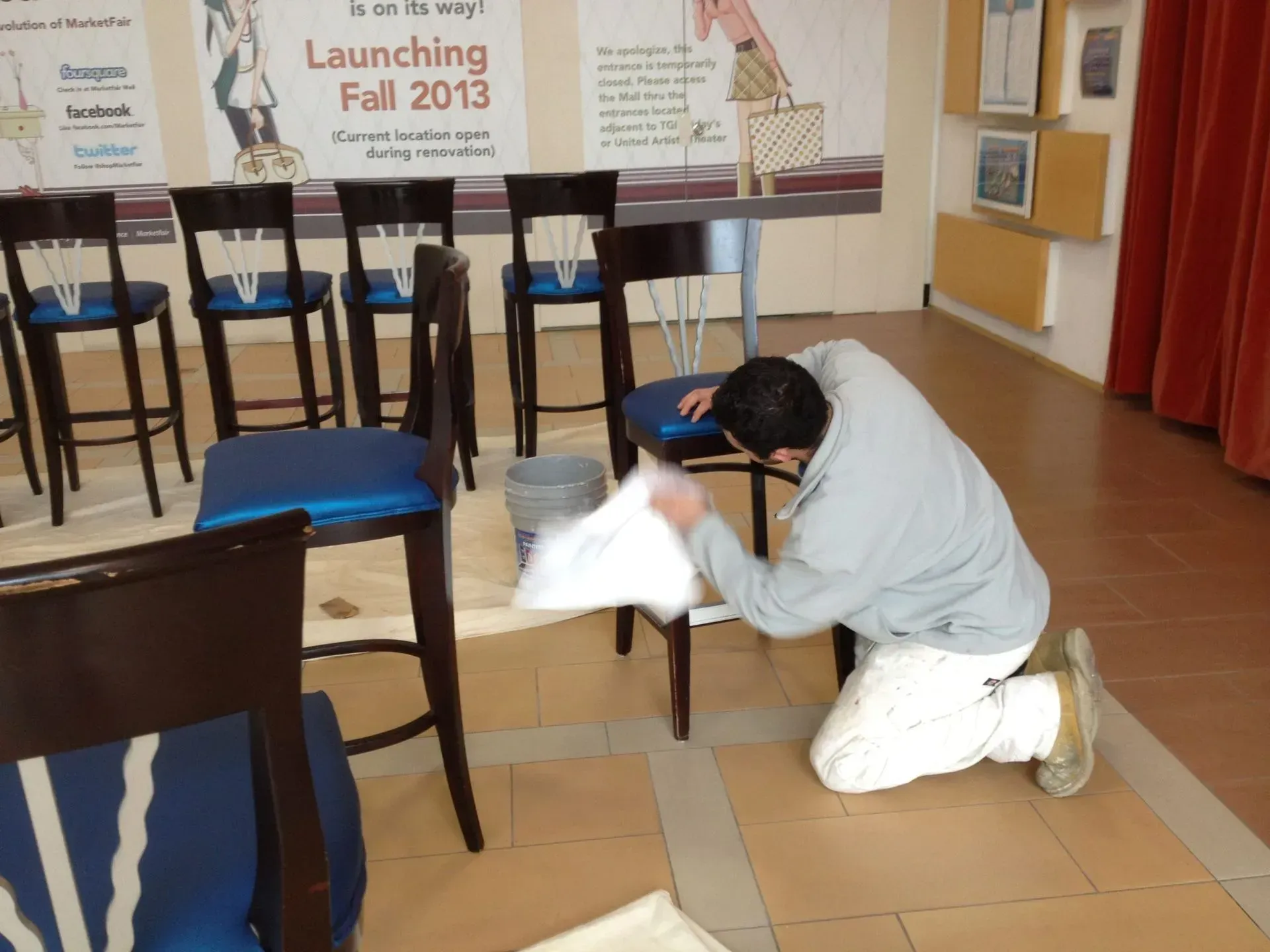 A man kneeling down in front of a sign that says launching fall 2013