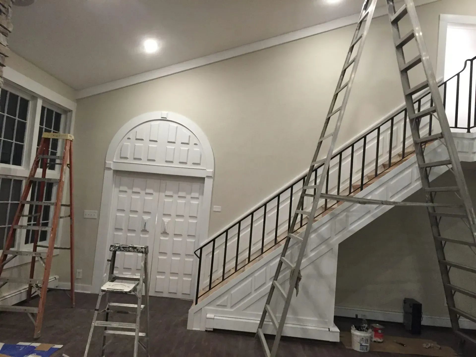 A room with a staircase and two ladders in it.
