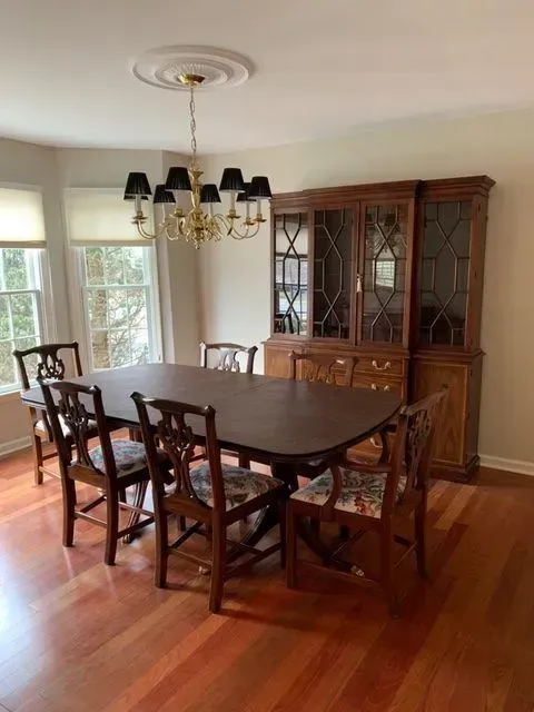 A dining room with a table and chairs and a chandelier