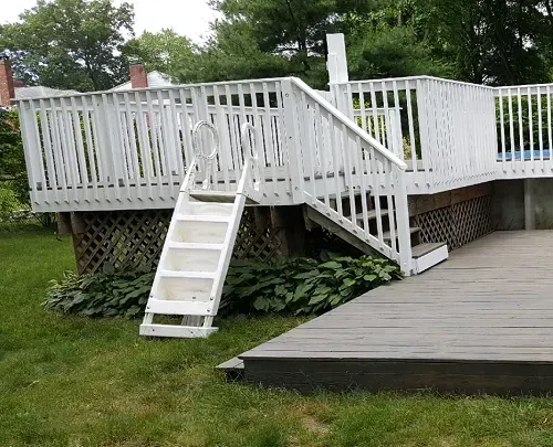 A white deck with stairs leading up to it