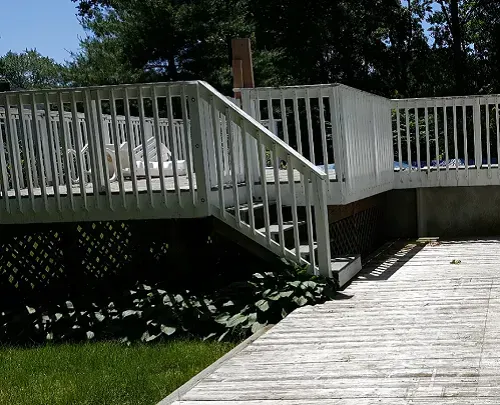 A white deck with stairs leading up to it