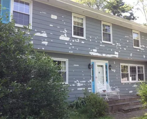 A house with peeling paint on the side of it.