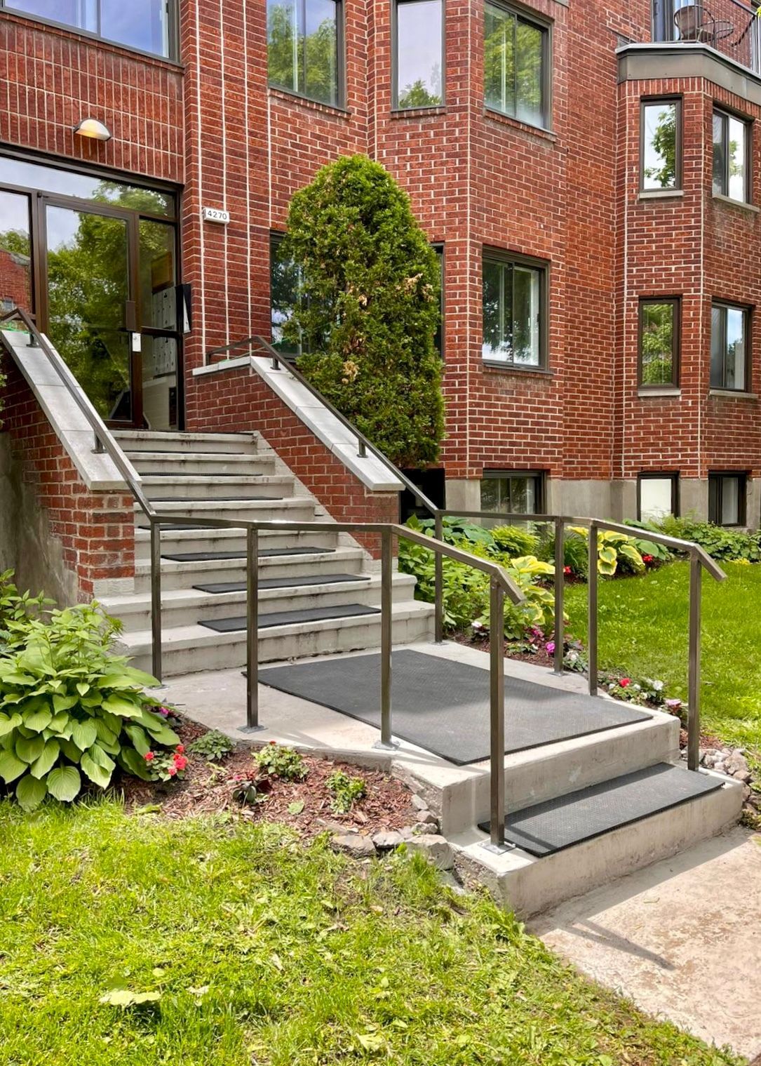 Un bâtiment en briques avec des escaliers menant à l'entrée.