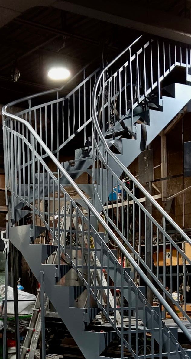 Un escalier en métal avec une rampe courbée dans un bâtiment.