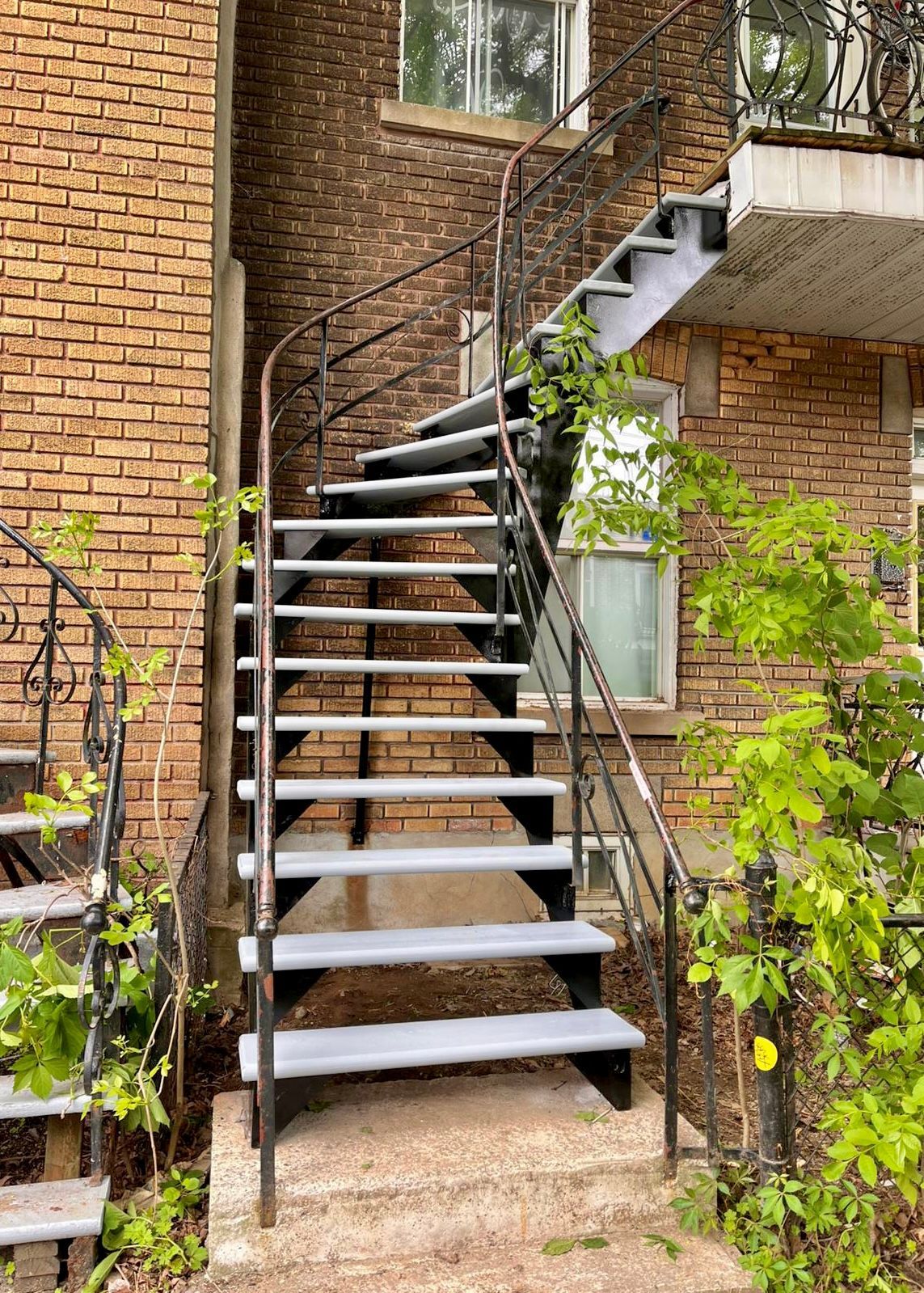 Un ensemble d'escaliers menant au deuxième étage d'un immeuble en briques.