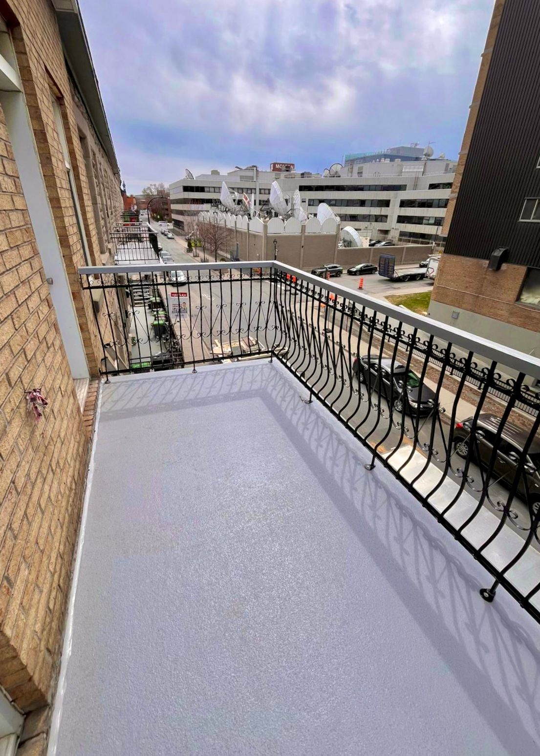 Un balcon avec une balustrade en fer forgé et une vue sur une ville.