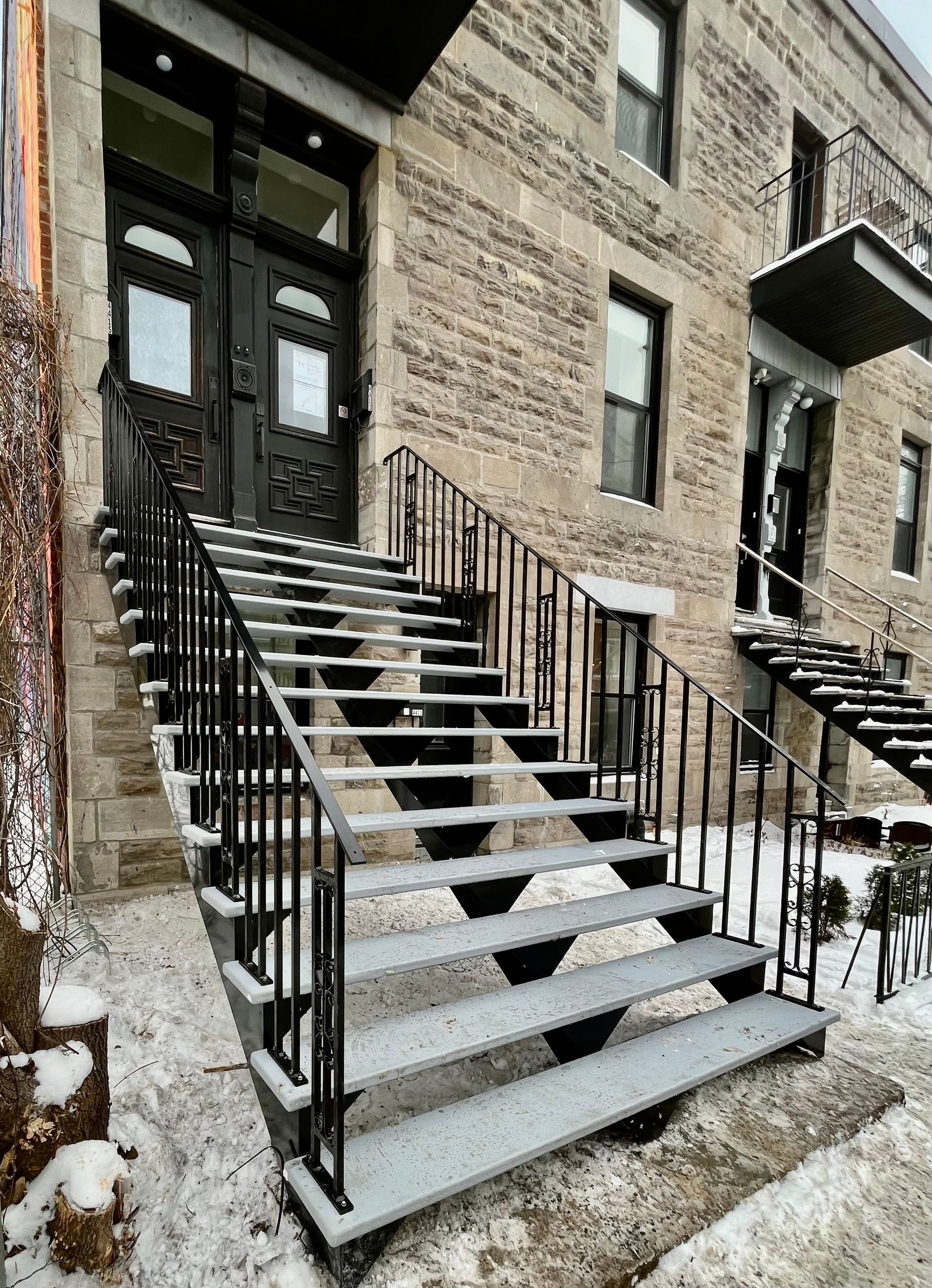 Un ensemble d'escaliers menant à la porte d'entrée d'un bâtiment en briques.