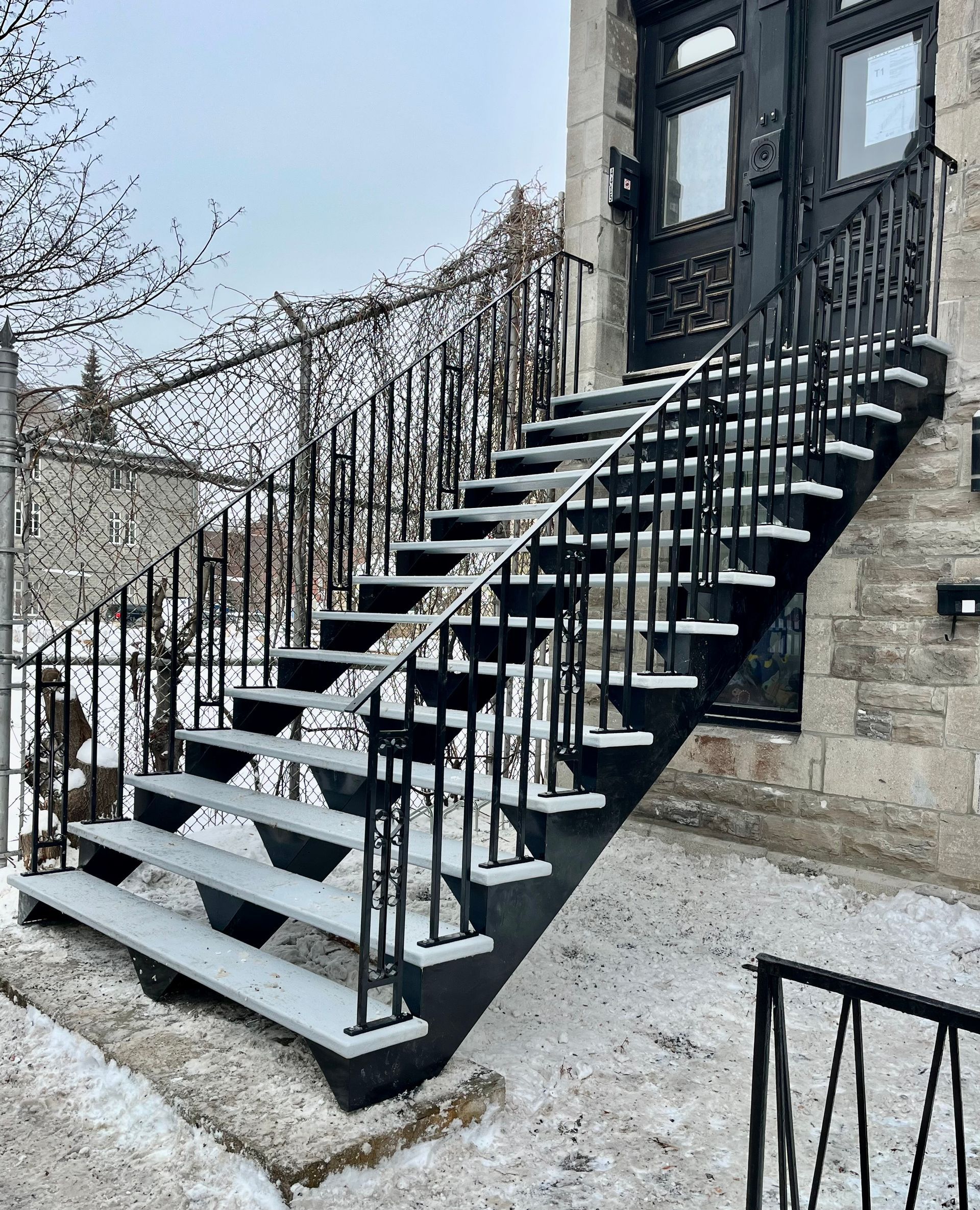 Un ensemble d'escaliers menant à un bâtiment avec de la neige au sol.