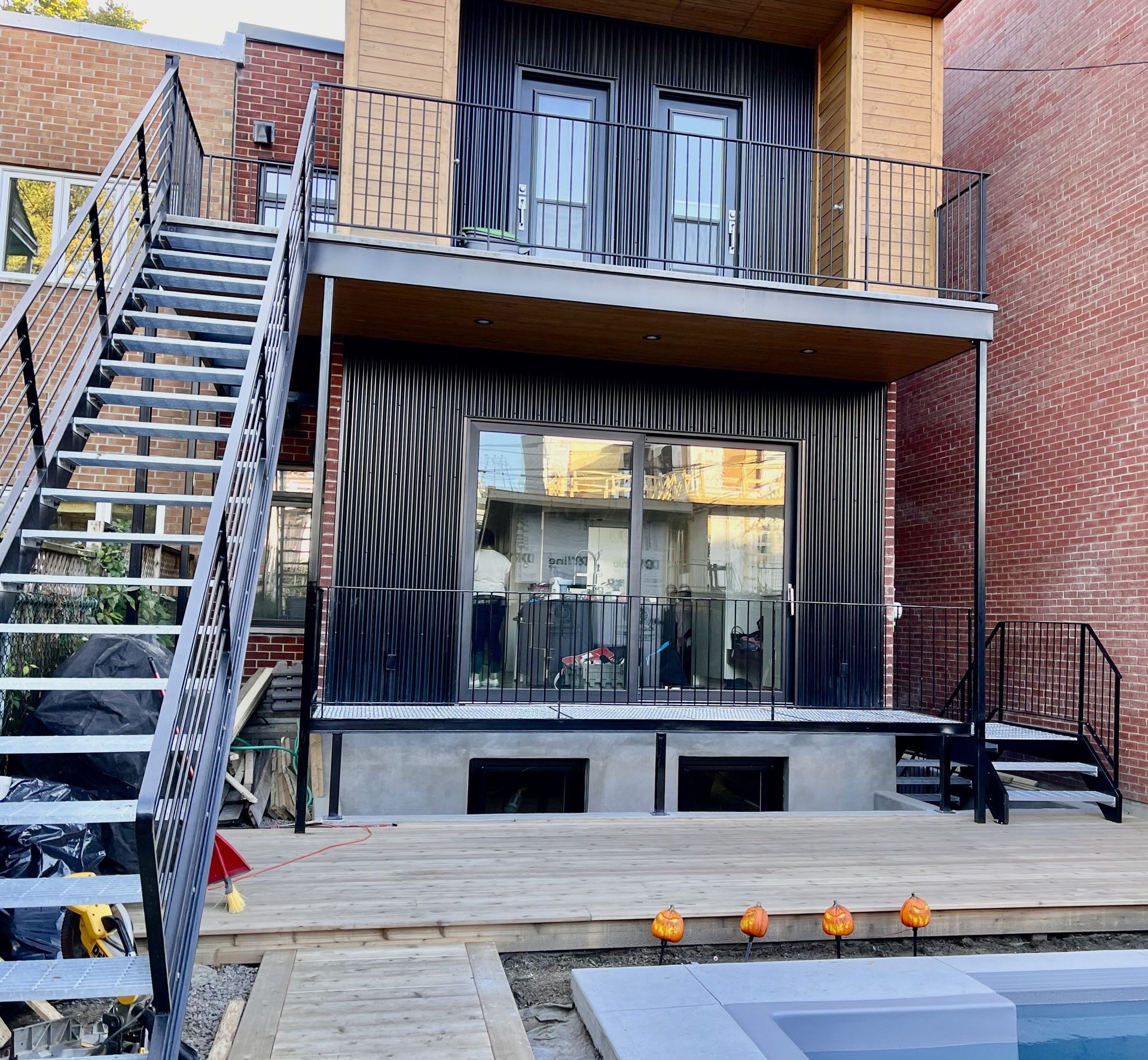 Une maison avec des escaliers qui y mènent et une piscine devant
