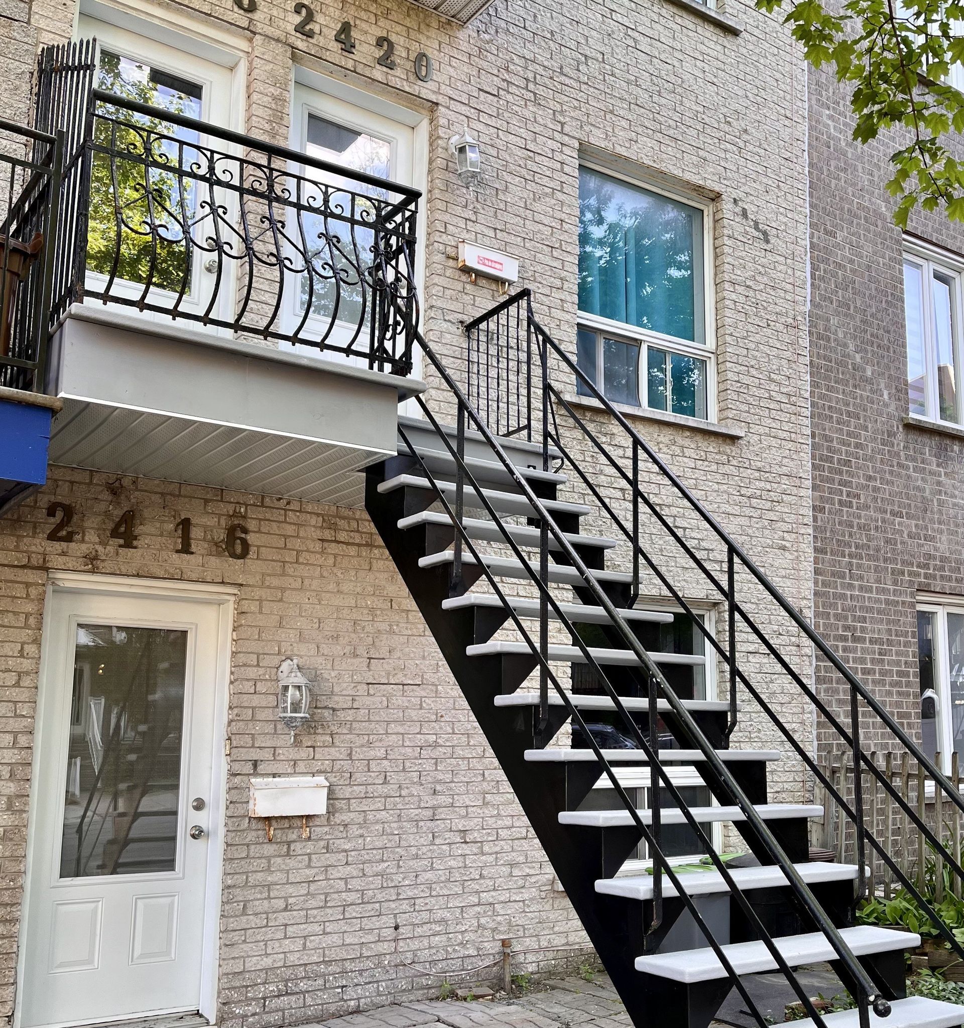 Un immeuble en brique avec des escaliers menant au deuxième étage