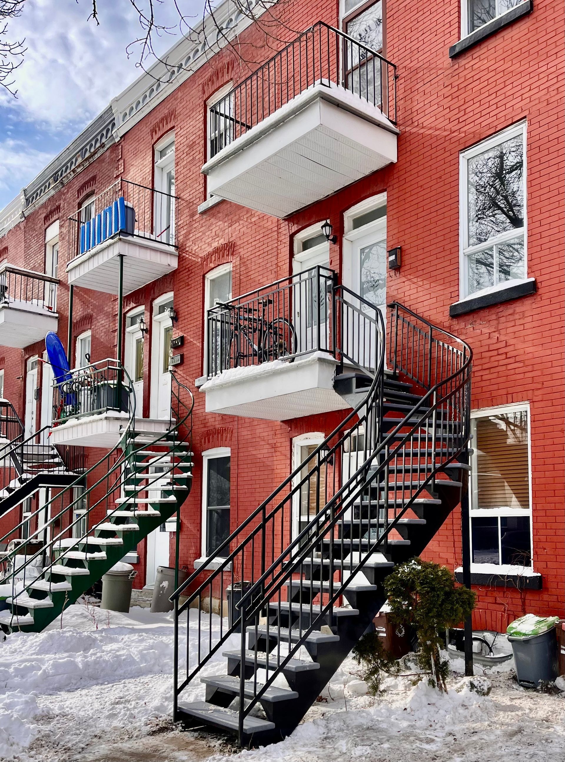 Un bâtiment en briques rouges avec des escaliers menant au deuxième étage.