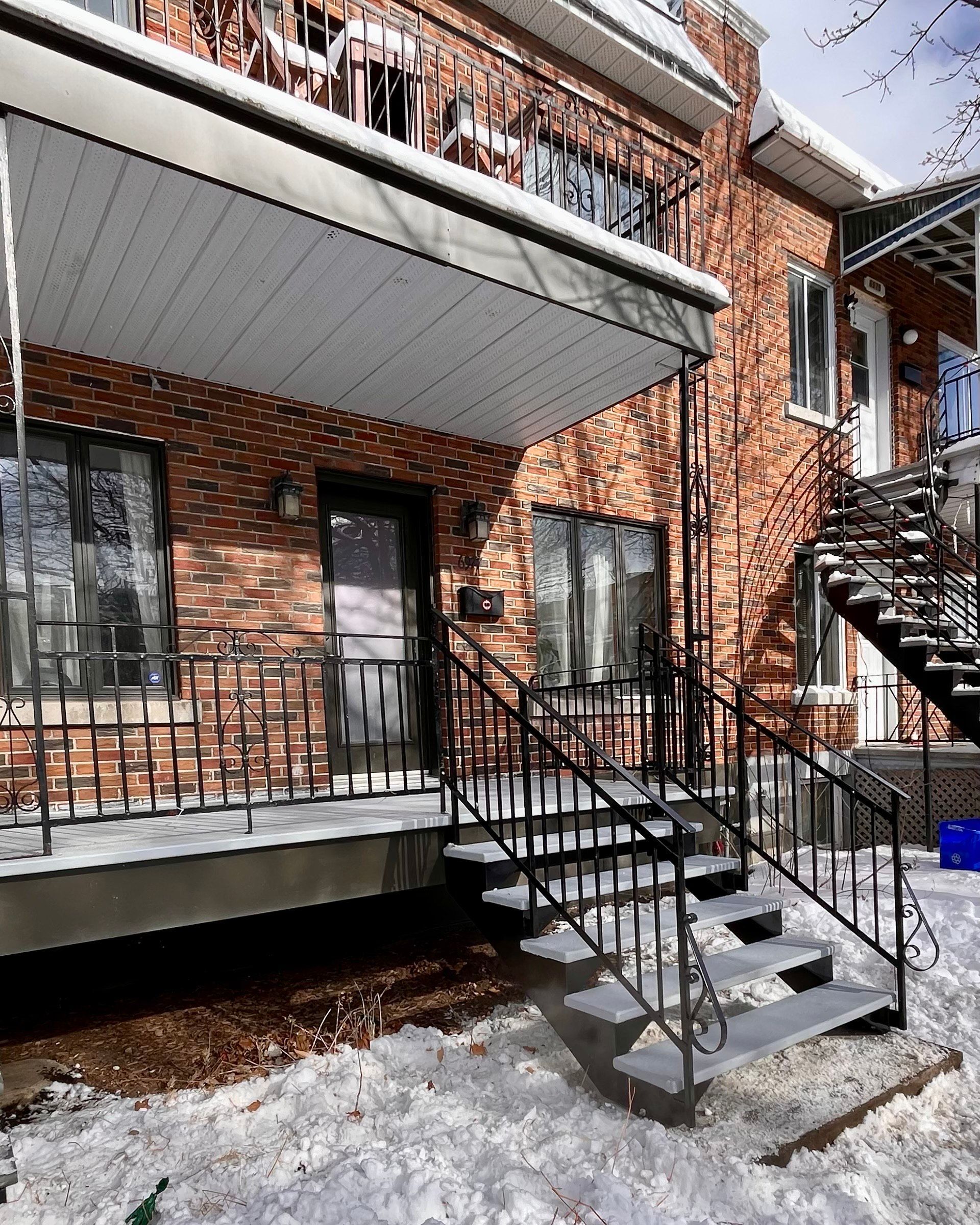 Une maison en briques avec des escaliers menant à la porte d'entrée
