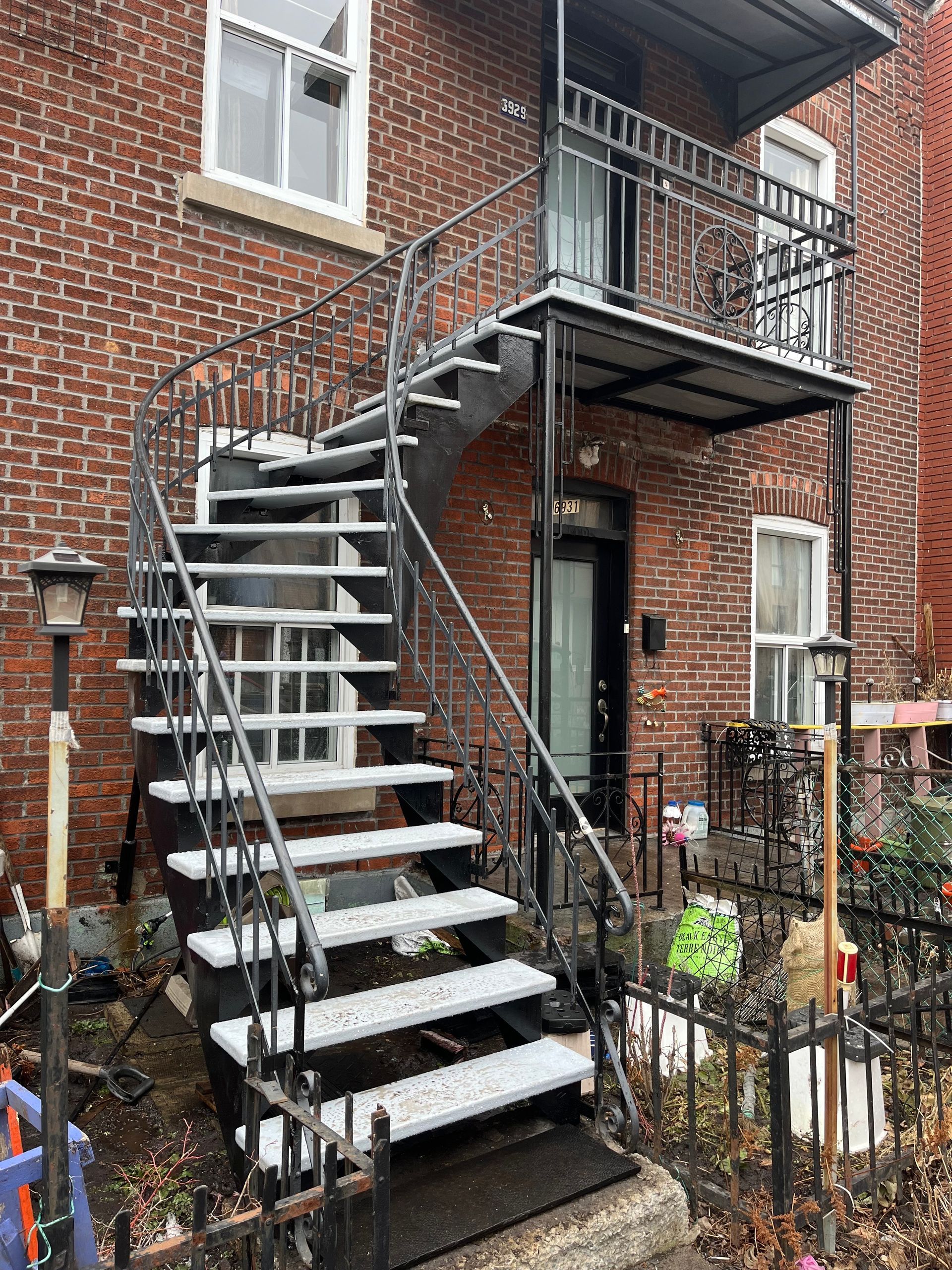 Un ensemble d'escaliers menant à un balcon sur le côté d'un bâtiment en briques.