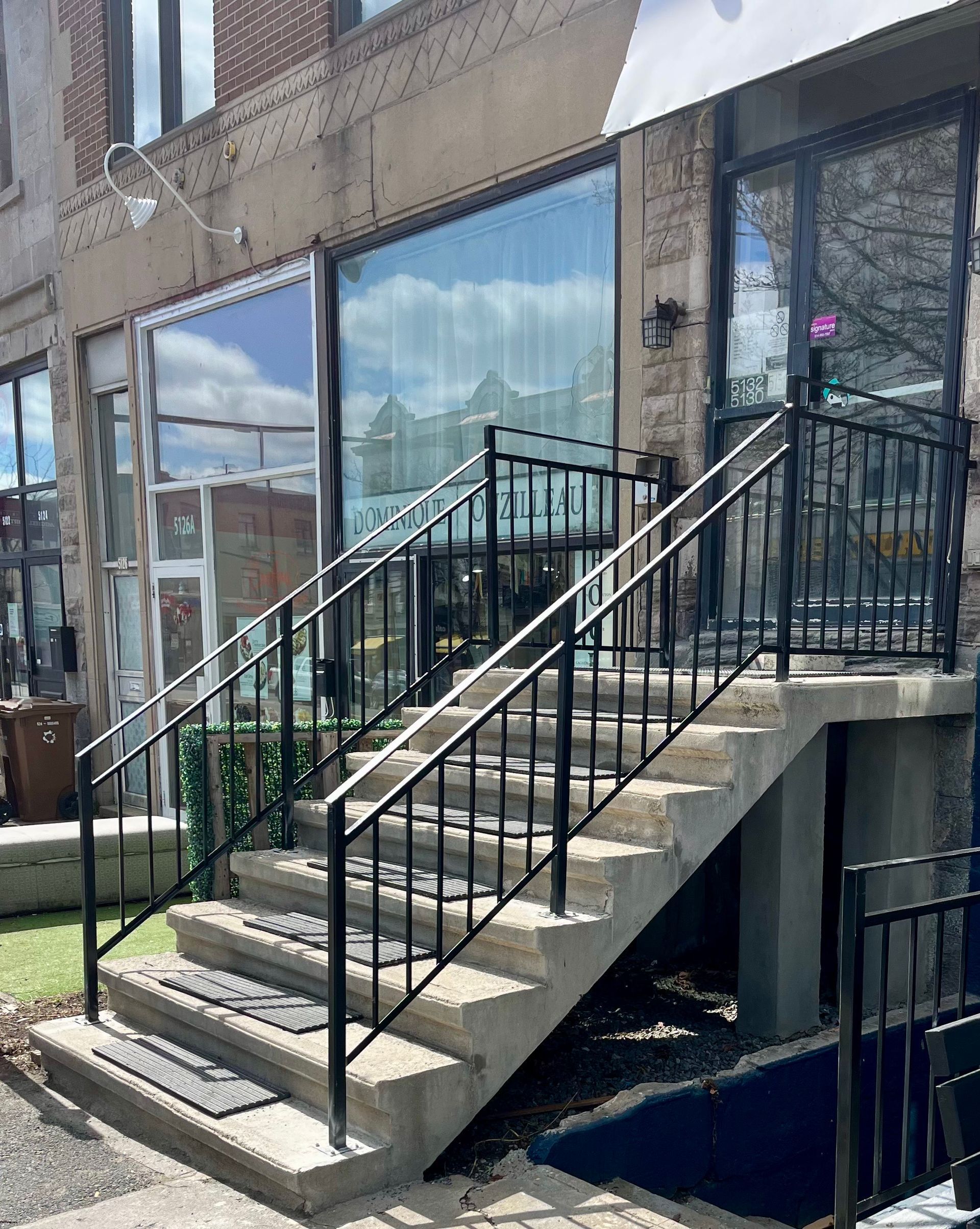 Un ensemble d'escaliers menant à un bâtiment avec une rampe en métal.