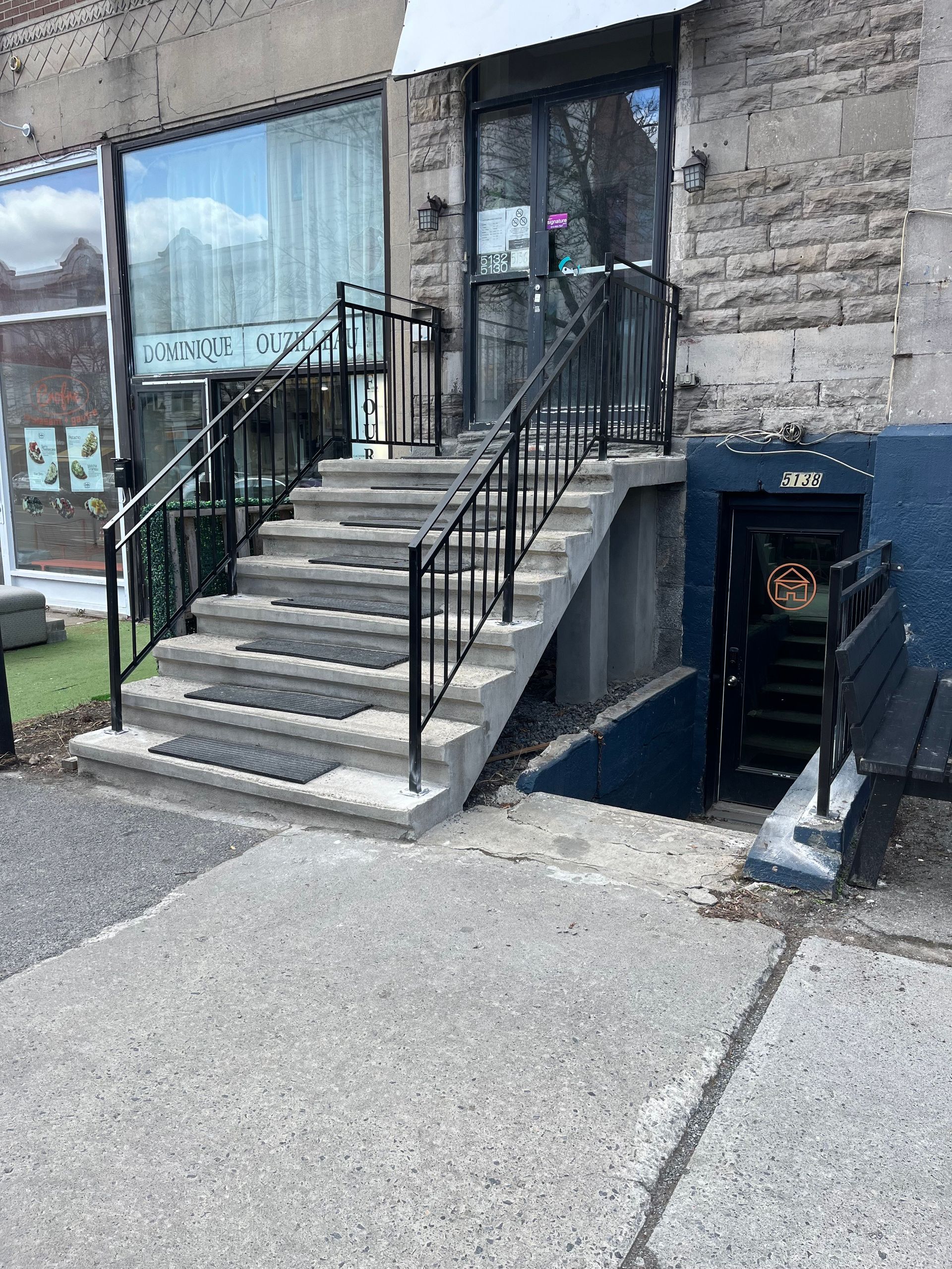 Un ensemble d'escaliers menant à un bâtiment avec une rampe en métal.