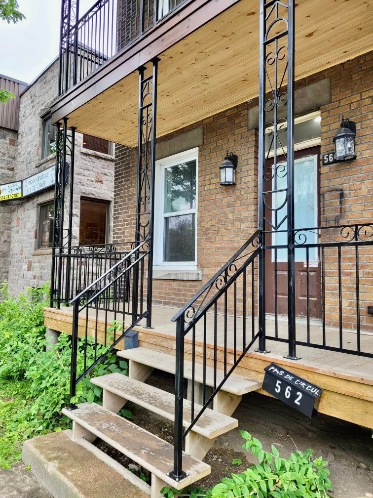 La façade d'un immeuble en brique avec des escaliers et un balcon.